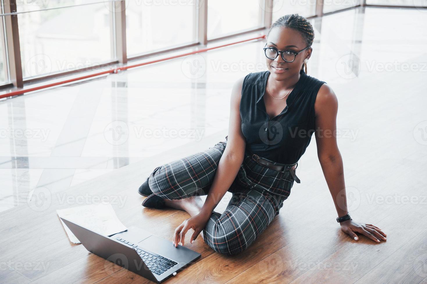 Eine junge Afroamerikanerin freut sich über einen Laptop. foto