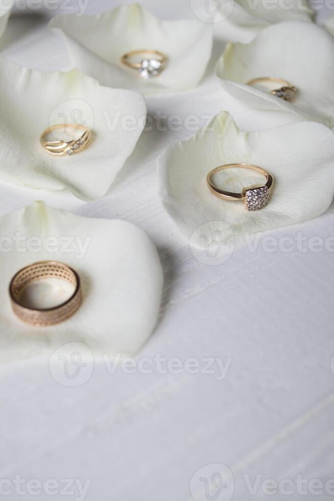golden Ringe auf ein Weiß Blütenblätter von Rosen. foto