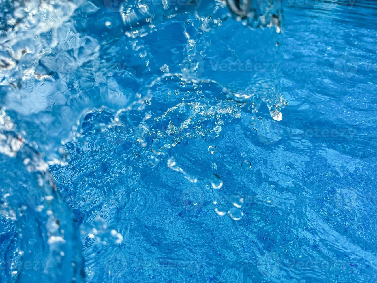 Hintergrund dynamisch Spritzen von klar Wasser Erstellen wirbelnd Welle im Blau Wasser mit Tröpfchen suspendiert im Bewegung. sauber Wasser Konzept. foto