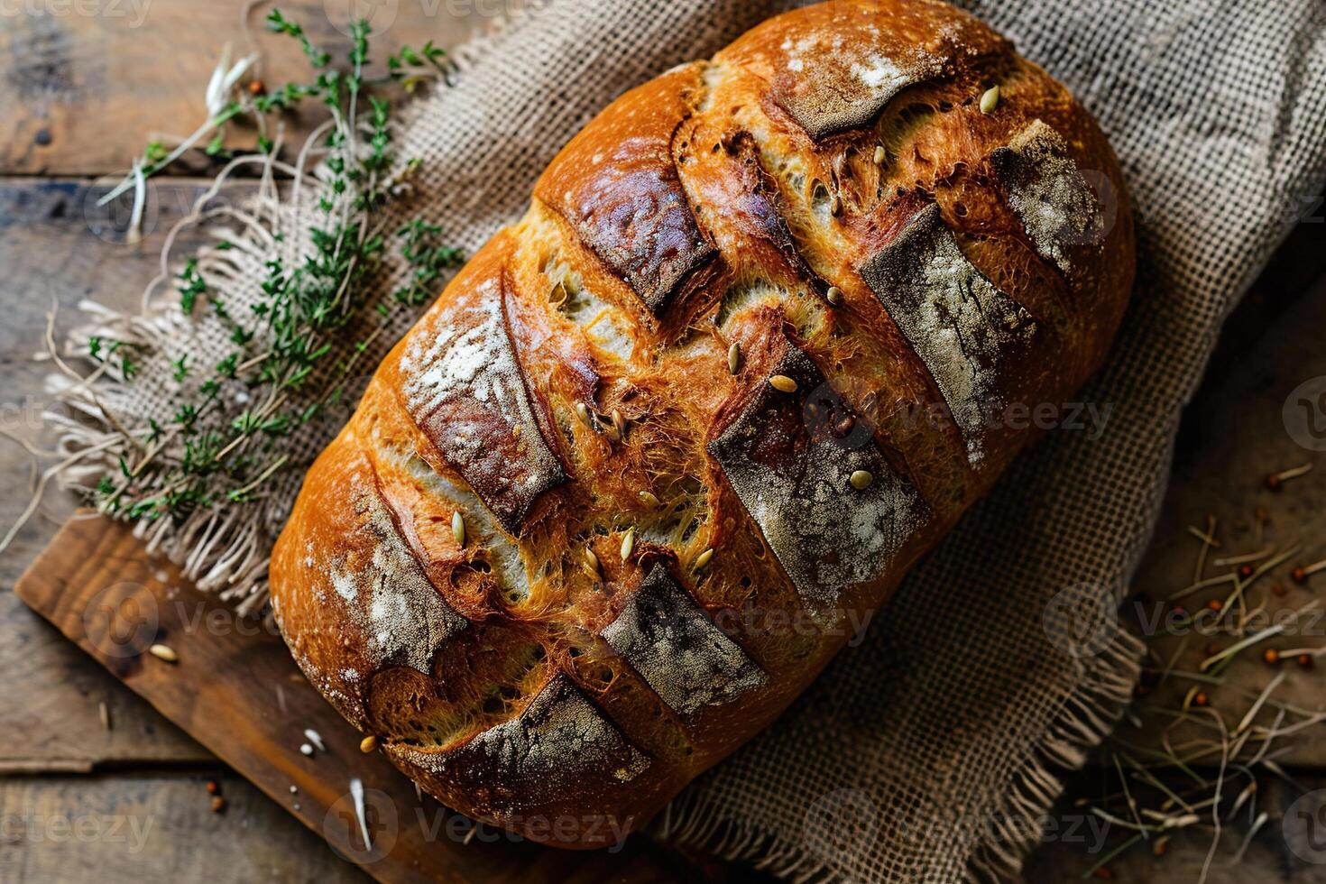 ein Laib von hausgemacht Brot auf ein hölzern Tabelle mit Sackleinen und Ohren von Mais. Aussicht von über. foto