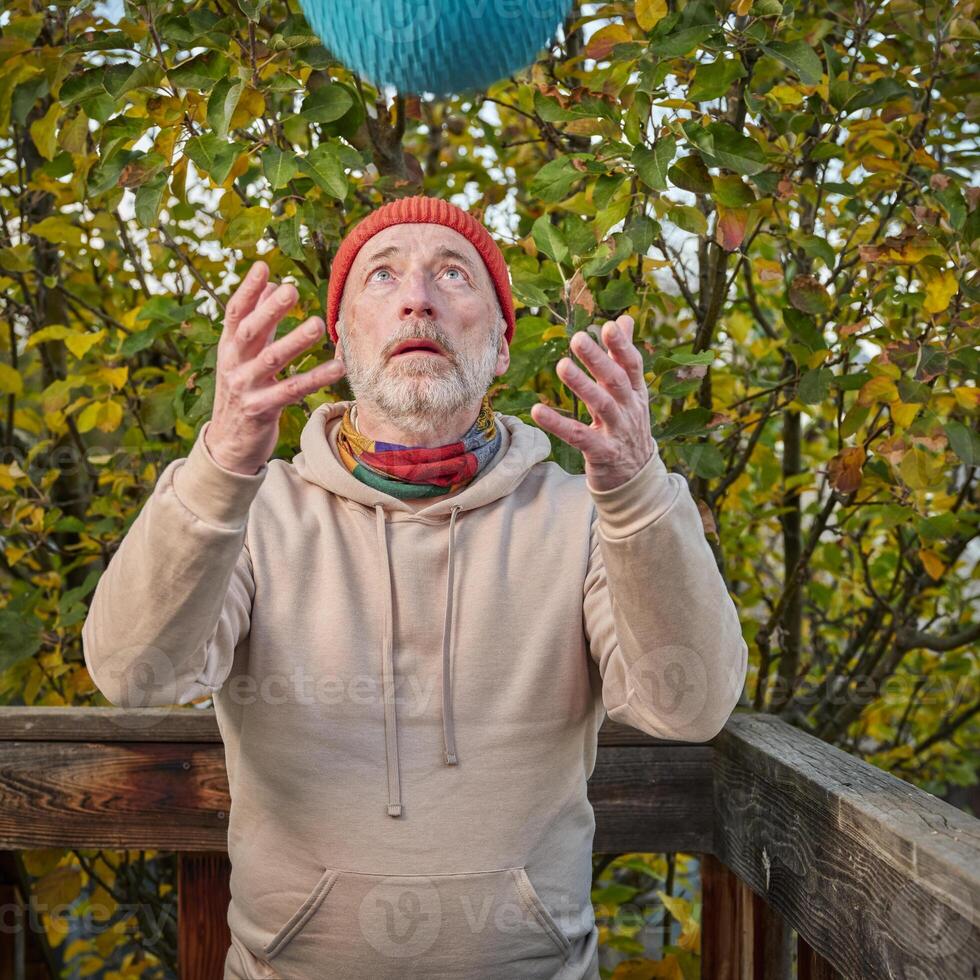 Senior Mann ist ausüben mit ein schwer zuschlagen Ball foto