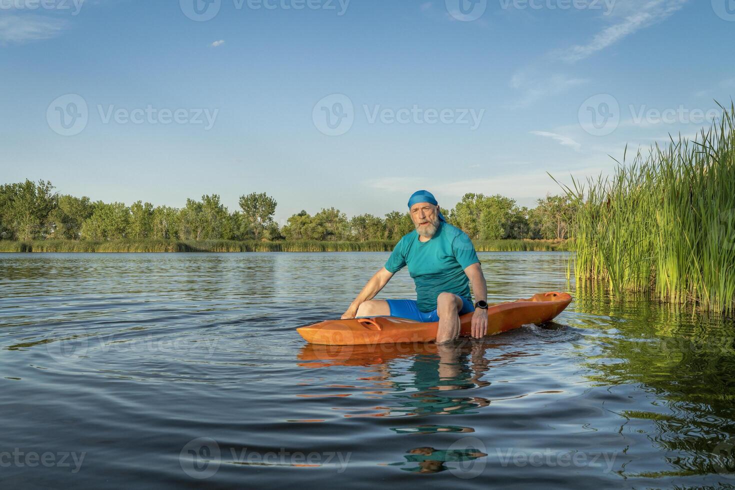 sportlich, Senior Mann ist Paddeln ein anfällig Kajak foto