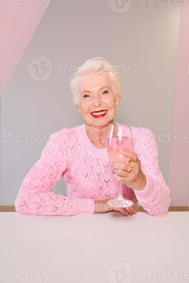 kaukasische stilvolle ältere Frau in der Bar, die Weißwein trinkt. Rente, Ruhestand, Alkohol, Mode, Lifestyle-Konzept foto