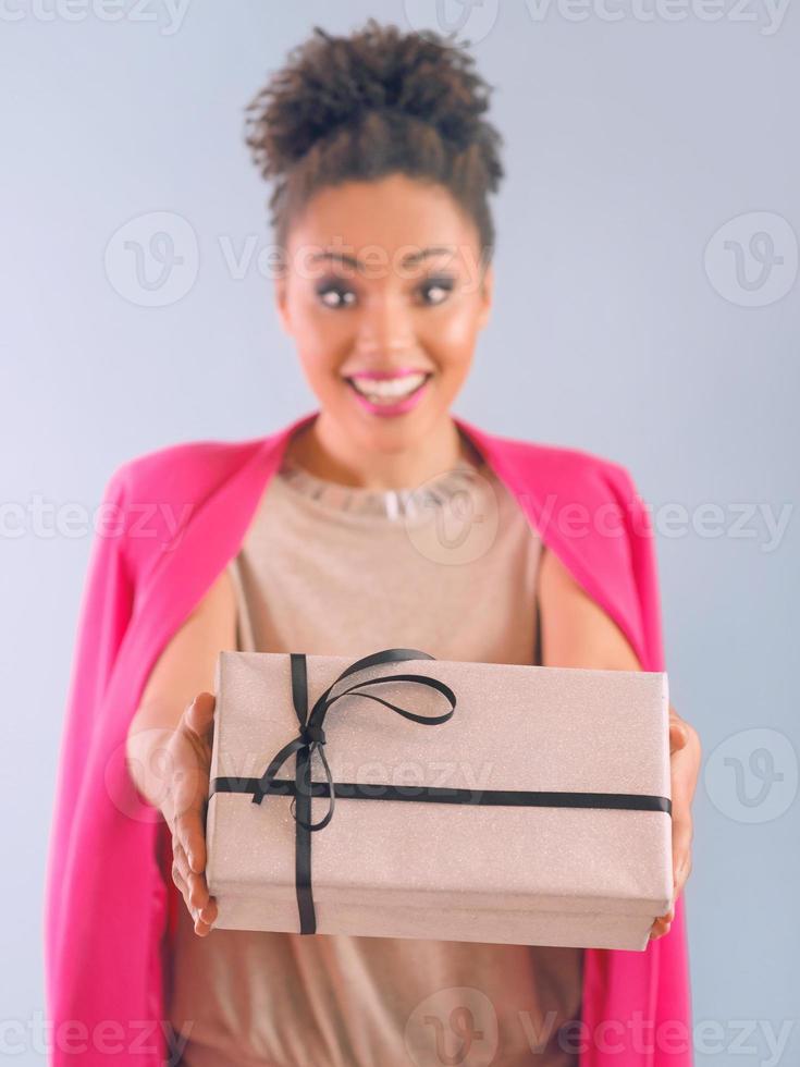 fröhliche und fröhliche Afroamerikanerin mit Geschenkbox foto