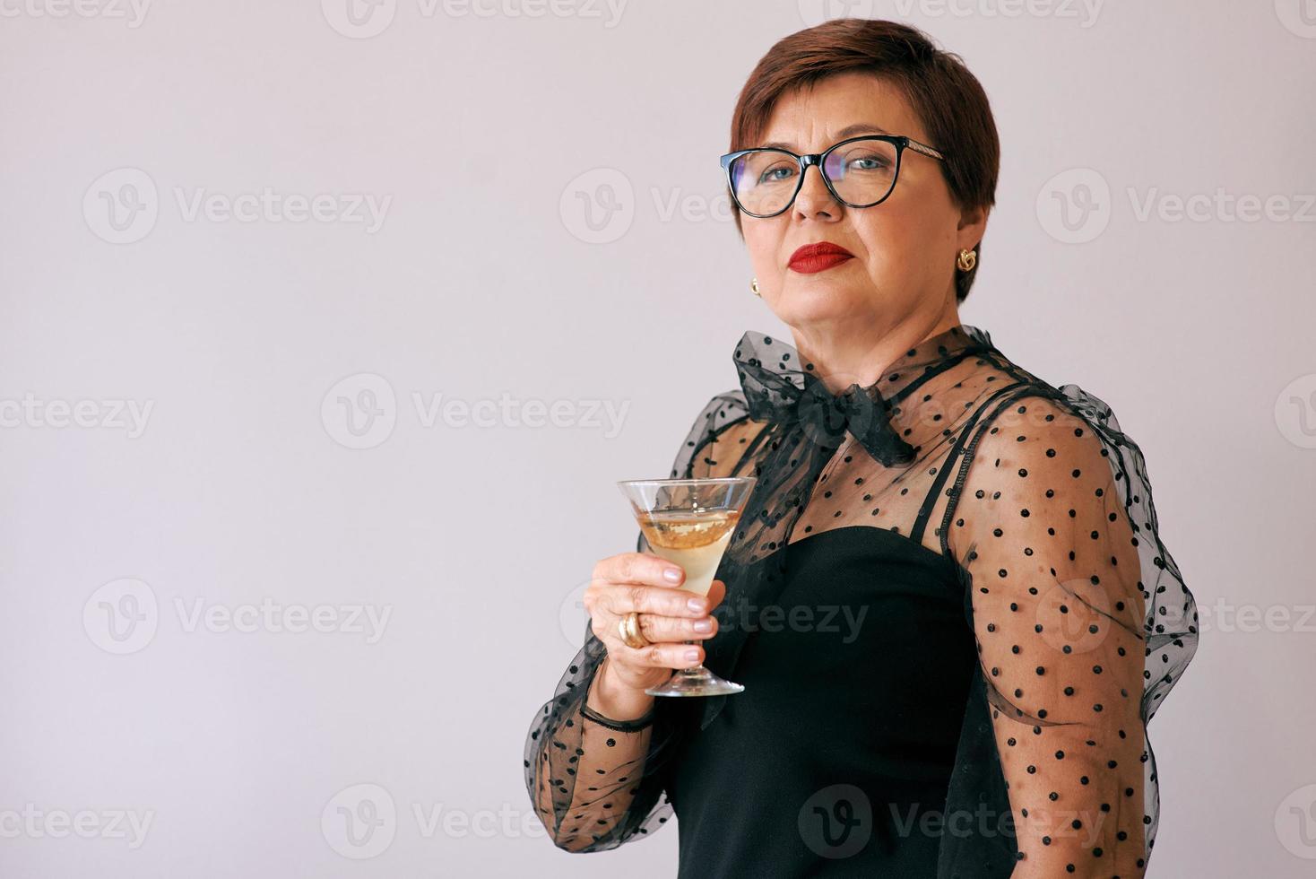 stilvolle reife ältere frau mit glas wein. Spaß, Party, Stil, Lifestyle, Arbeit, Alkohol, Feierkonzept foto