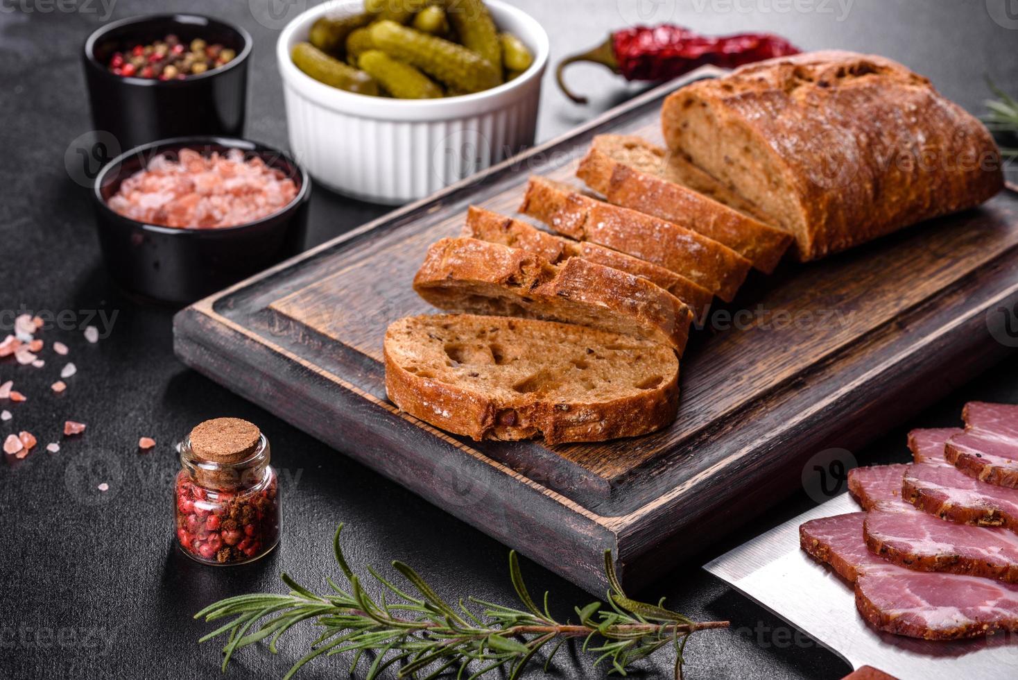 leckerer frischer Speck in Scheiben geschnitten mit Brot und Gemüse foto