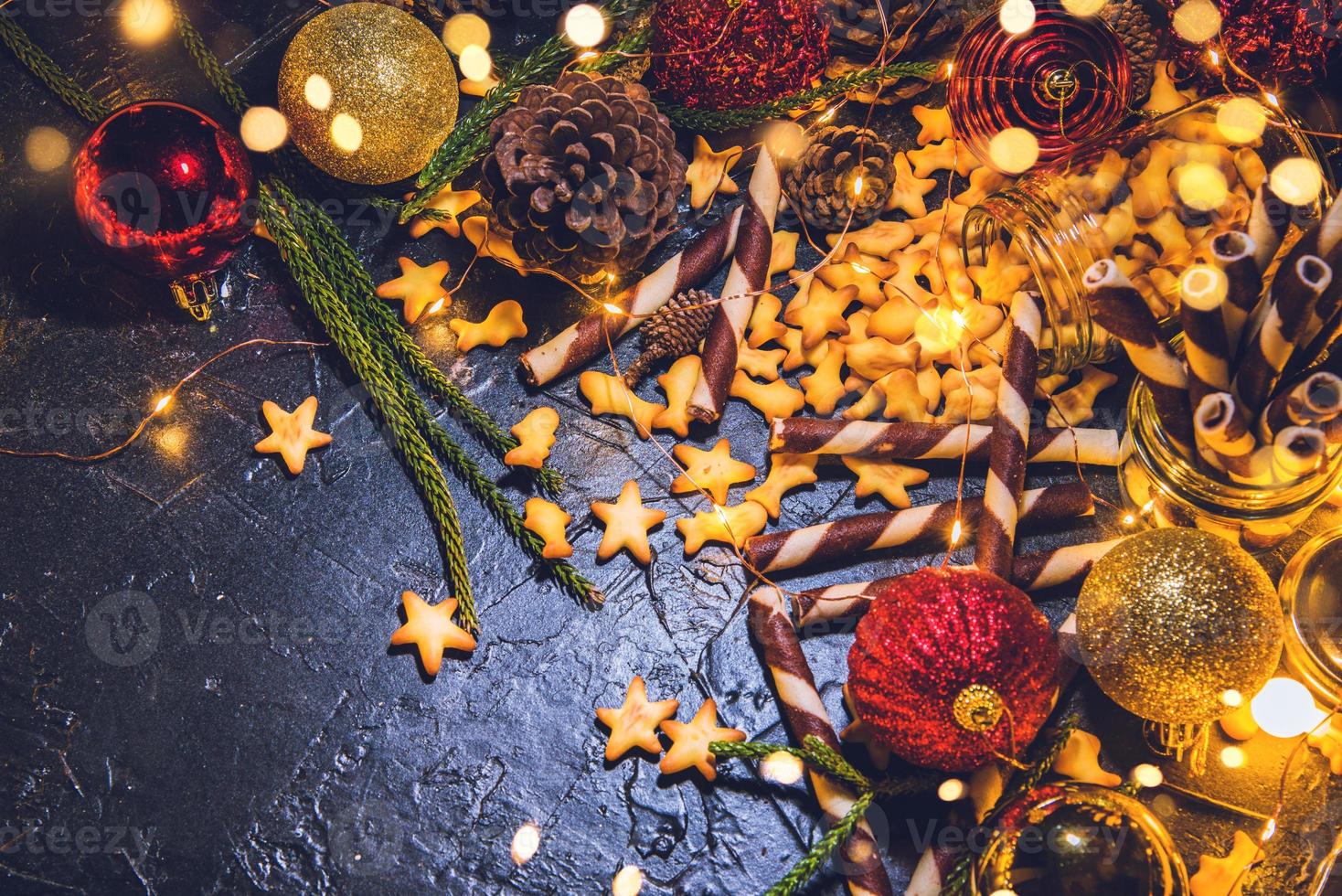 Weihnachtsdekorationskugeln mit Keksen und Gebäck auf abstraktem bokeh schwarzem Hintergrund mit Kopierraum und dekorativen LED-Leuchten. frohe weihnachten und neues jahr. Grußkarte. foto