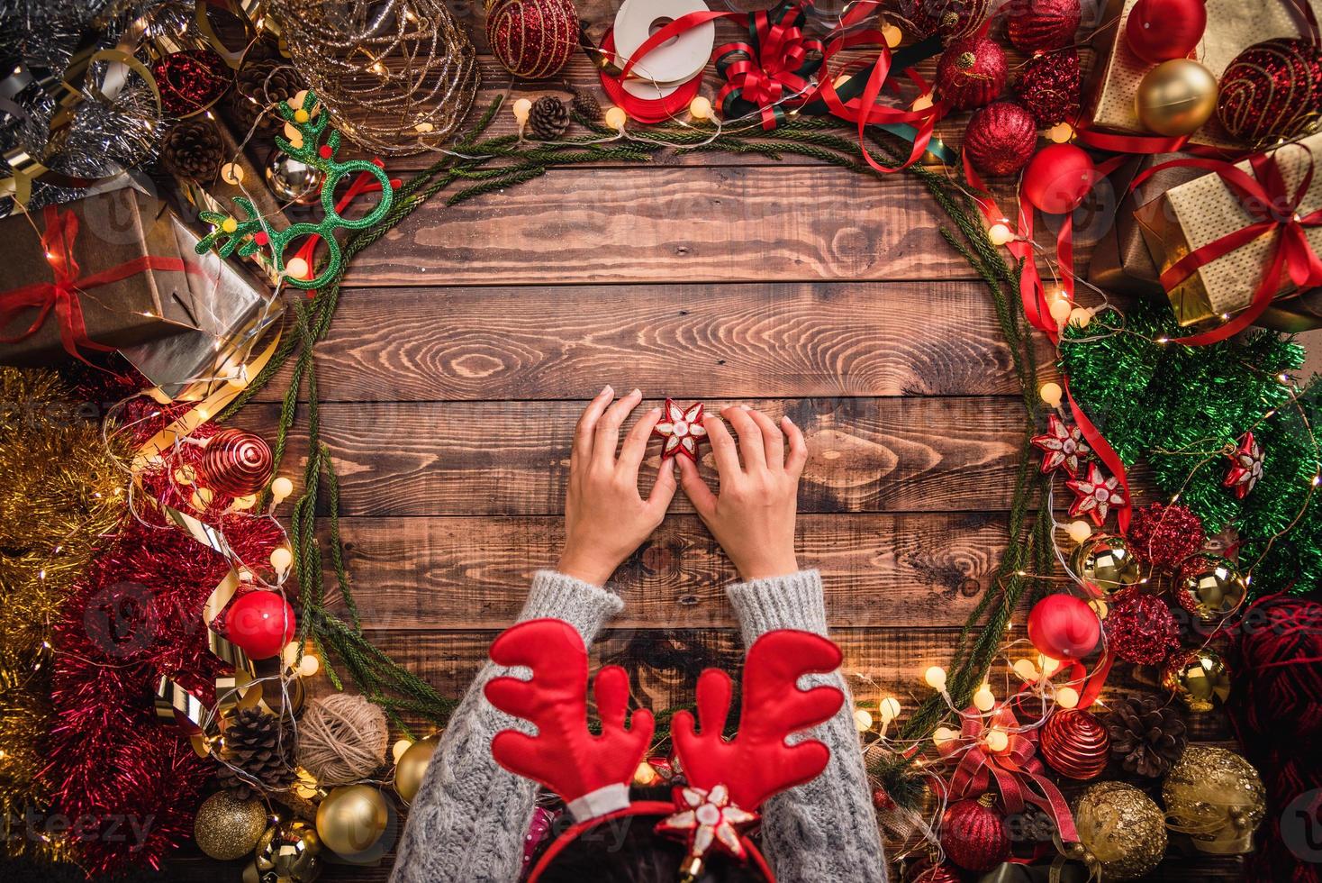 Mädchen, das Weihnachtsflachkomposition auf dem hölzernen Hintergrund mit Kopienraum für Ihren Text legt. Frohe Weihnachten und ein glückliches Neues Jahr. foto