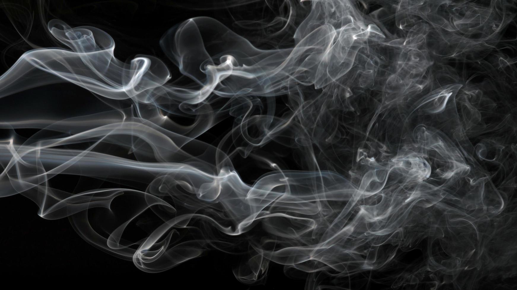 Rauch auf schwarzem Hintergrund isoliert. Bewegung von weißem Rauch foto