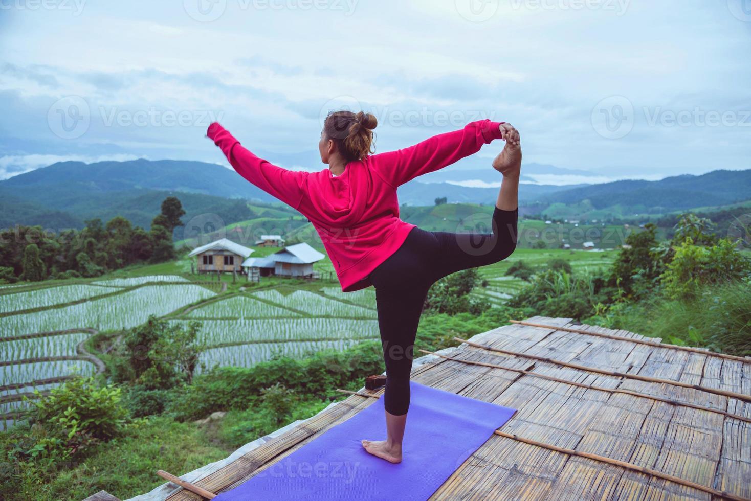 asiatische frau entspannen sich im urlaub. spielen, wenn Yoga. auf der balkonlandschaft naturfeld.papongpieng in thailand foto