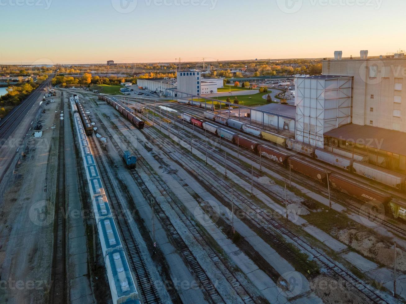 Luftaufnahme von Rangierbahnhof und städtischen Gebäuden bei Sonnenuntergang foto