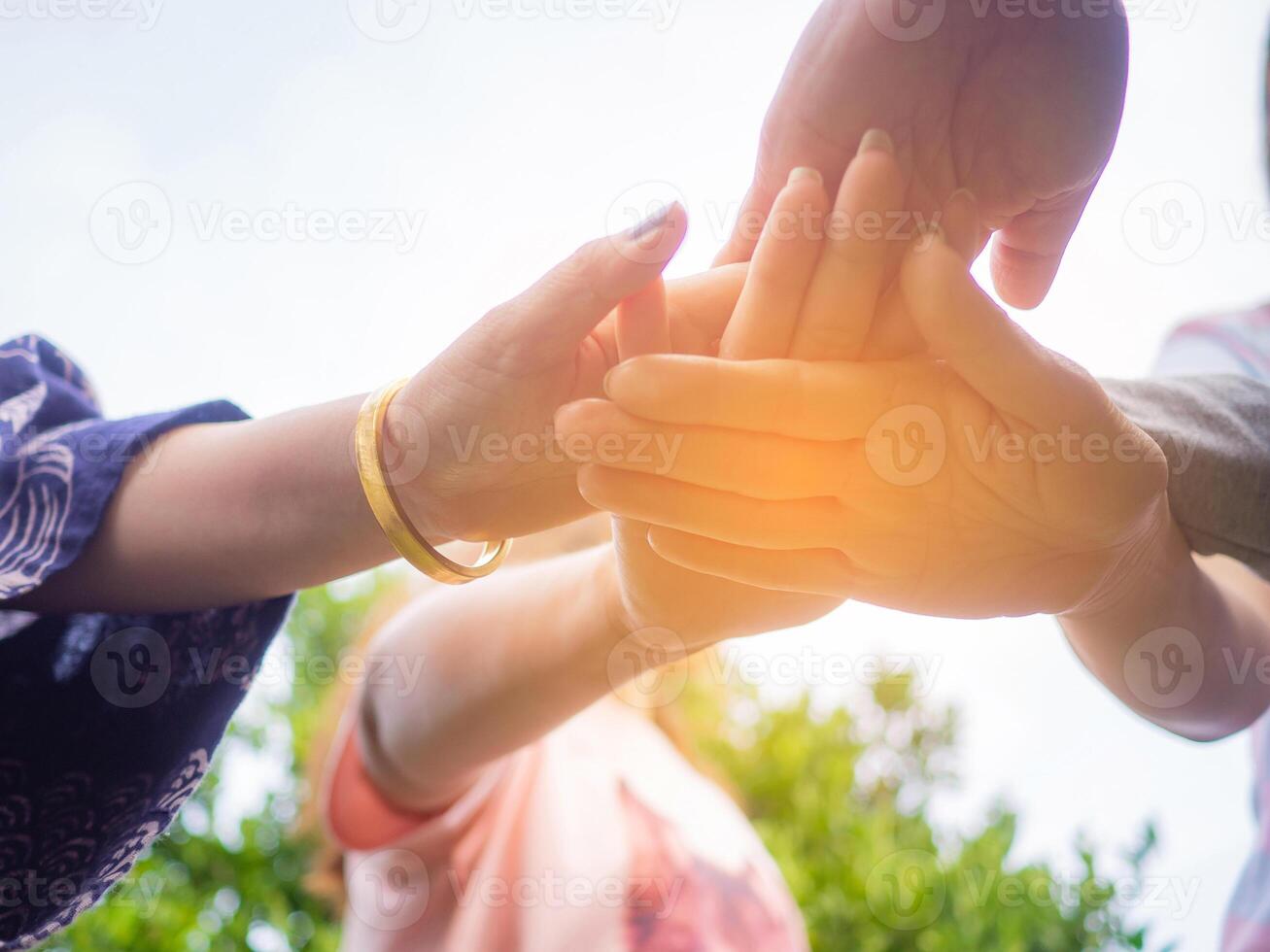 Nahansicht Unterseite Aussicht von Hände Frauen und Kind Putten ihre zusammen. Familie mit ein Stapel von Hände zeigen Einheit und Zusammenarbeit foto