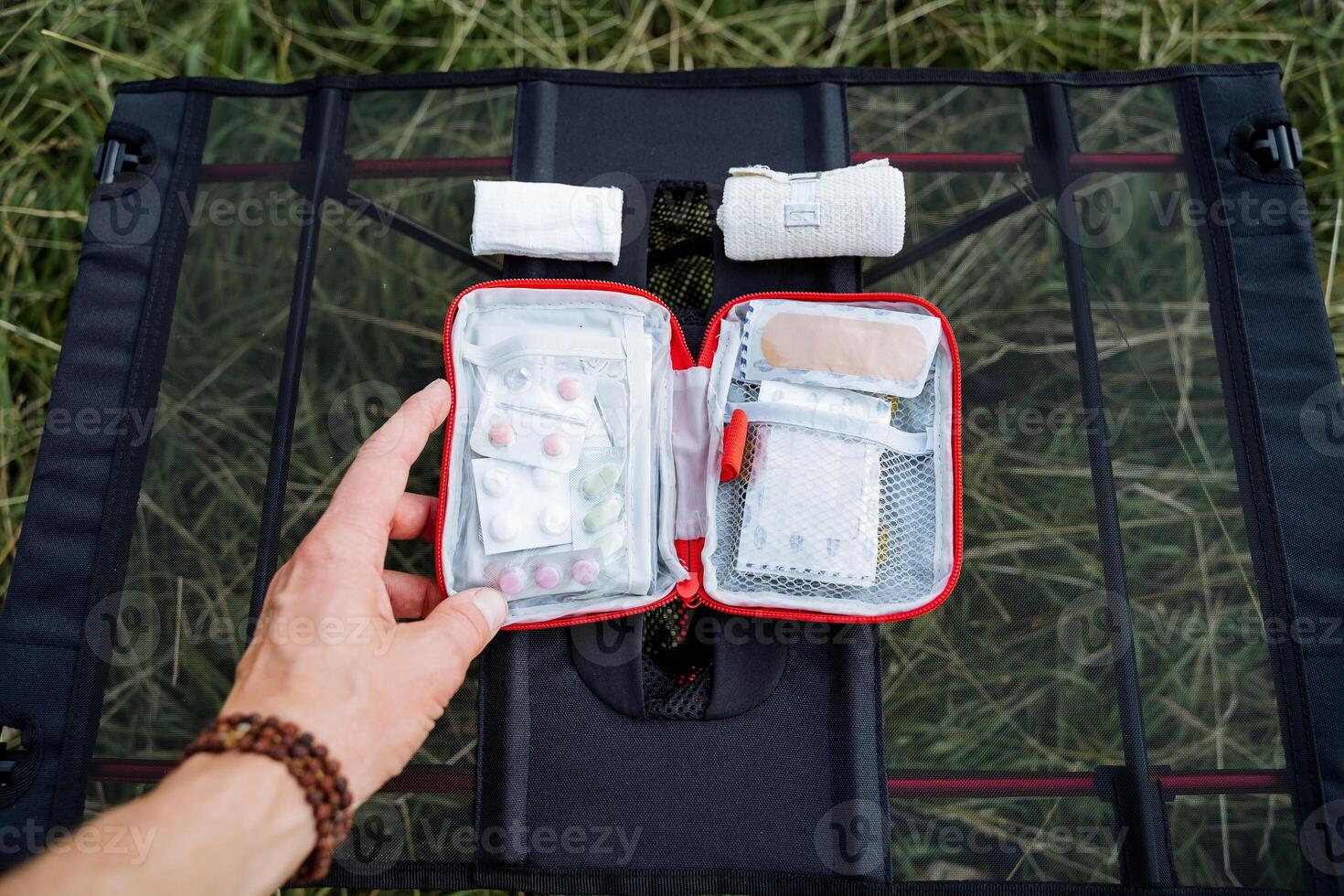 zuerst Hilfe Kit öffnen oben Aussicht von das Drogen zum Anästhesie im Fall von Verletzung auf ein Reise, ein Wandern Kit von Medikamente, Bandagen zum Dressing das Wunde, ein Patch im das einstellen foto