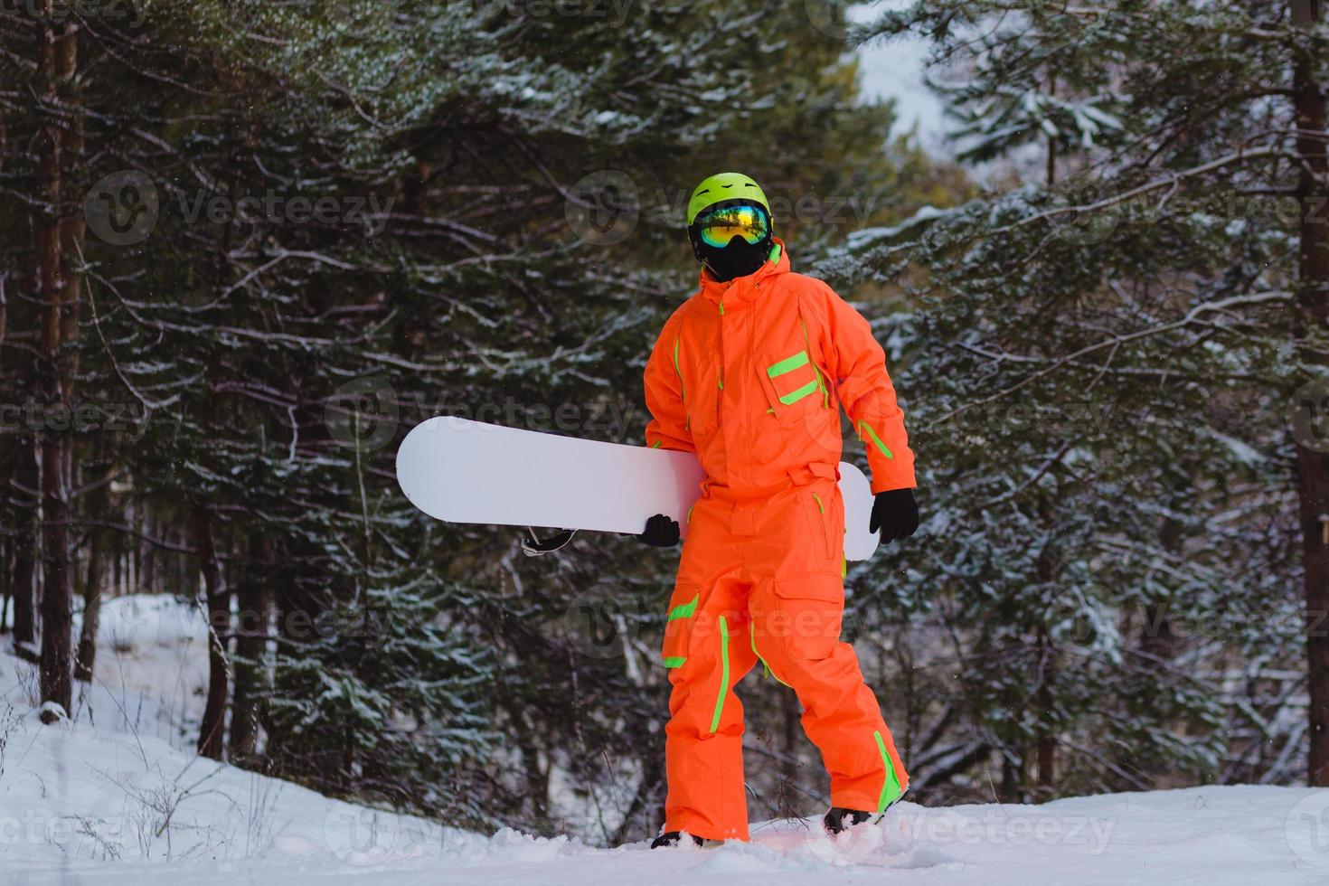 Snowboarder geht durch den Wald foto
