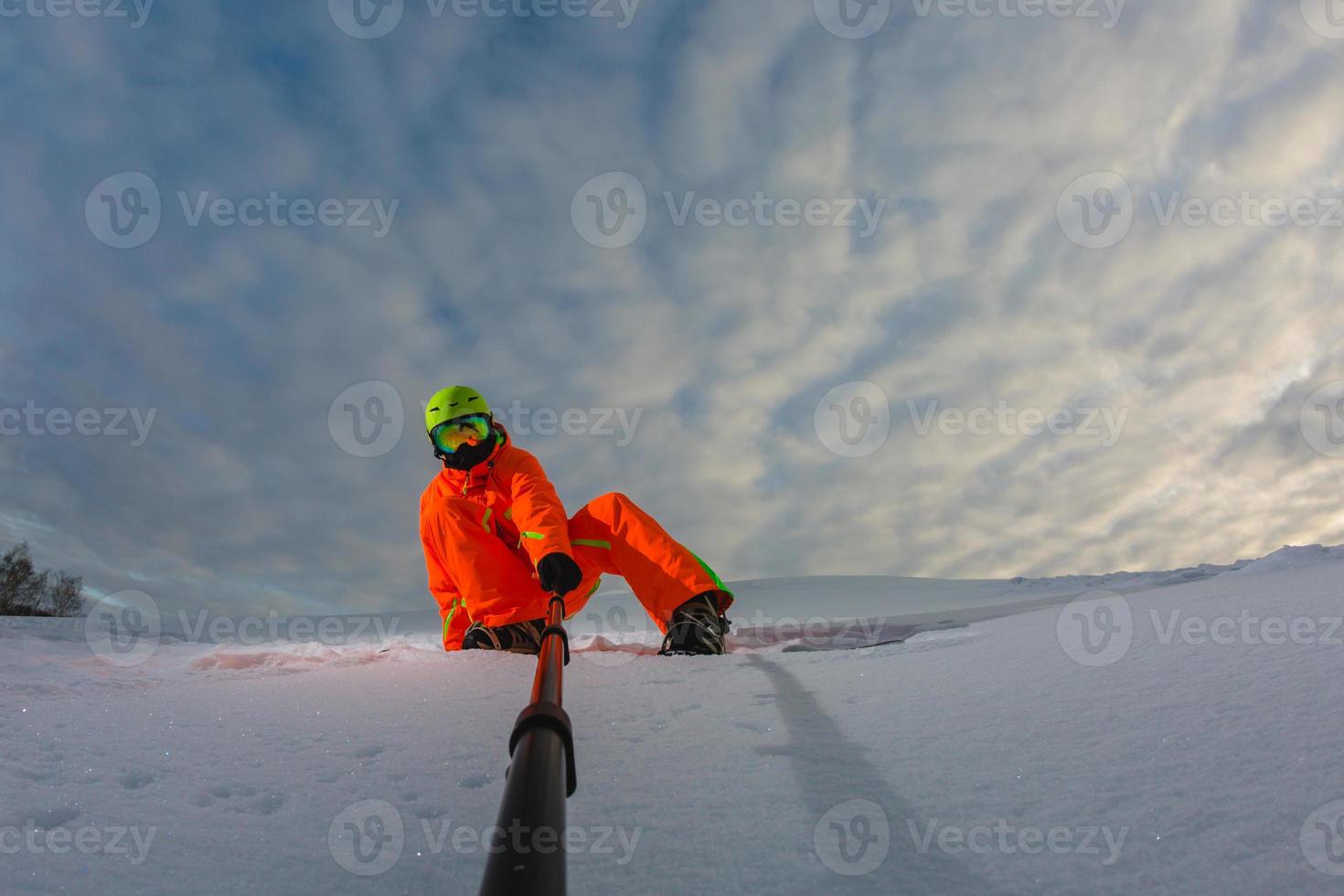 Snowboarder mit dem Snowboard macht ein Selfie foto