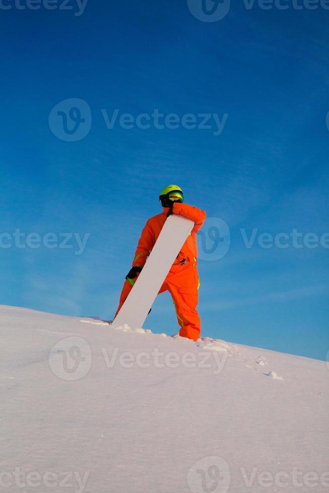 Snowboarder Freerider mit weißem Snowboard steht oben auf der Skipiste foto