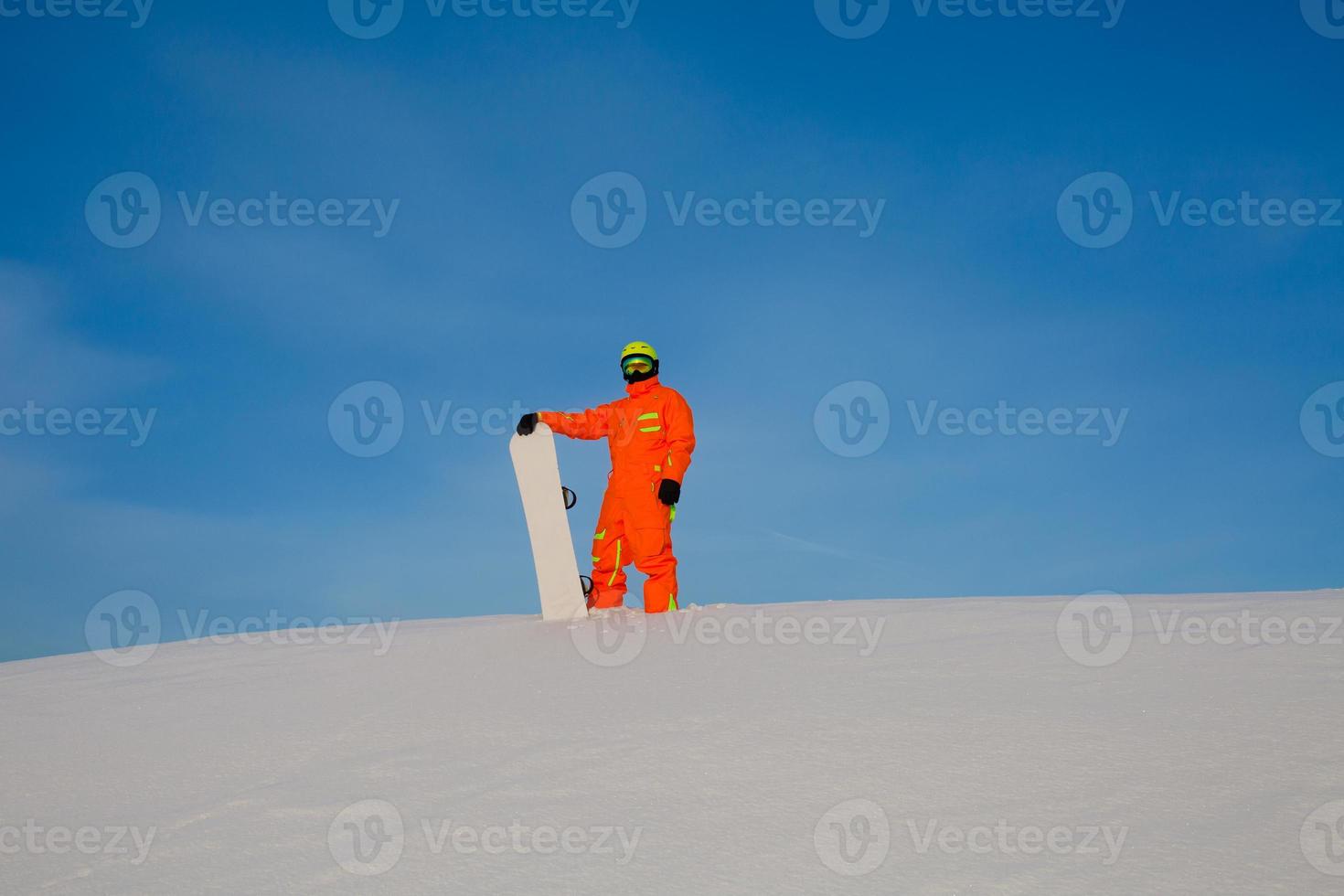 Snowboarder Freerider mit weißem Snowboard steht oben auf der Skipiste foto