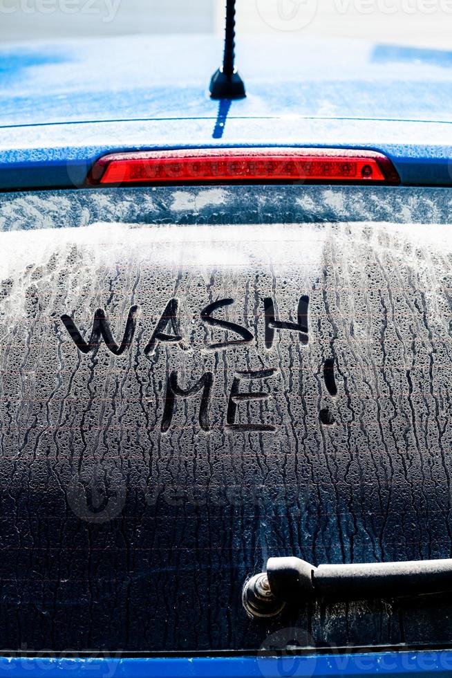 wasche mir Worte auf einem schmutzigen Autofenster foto