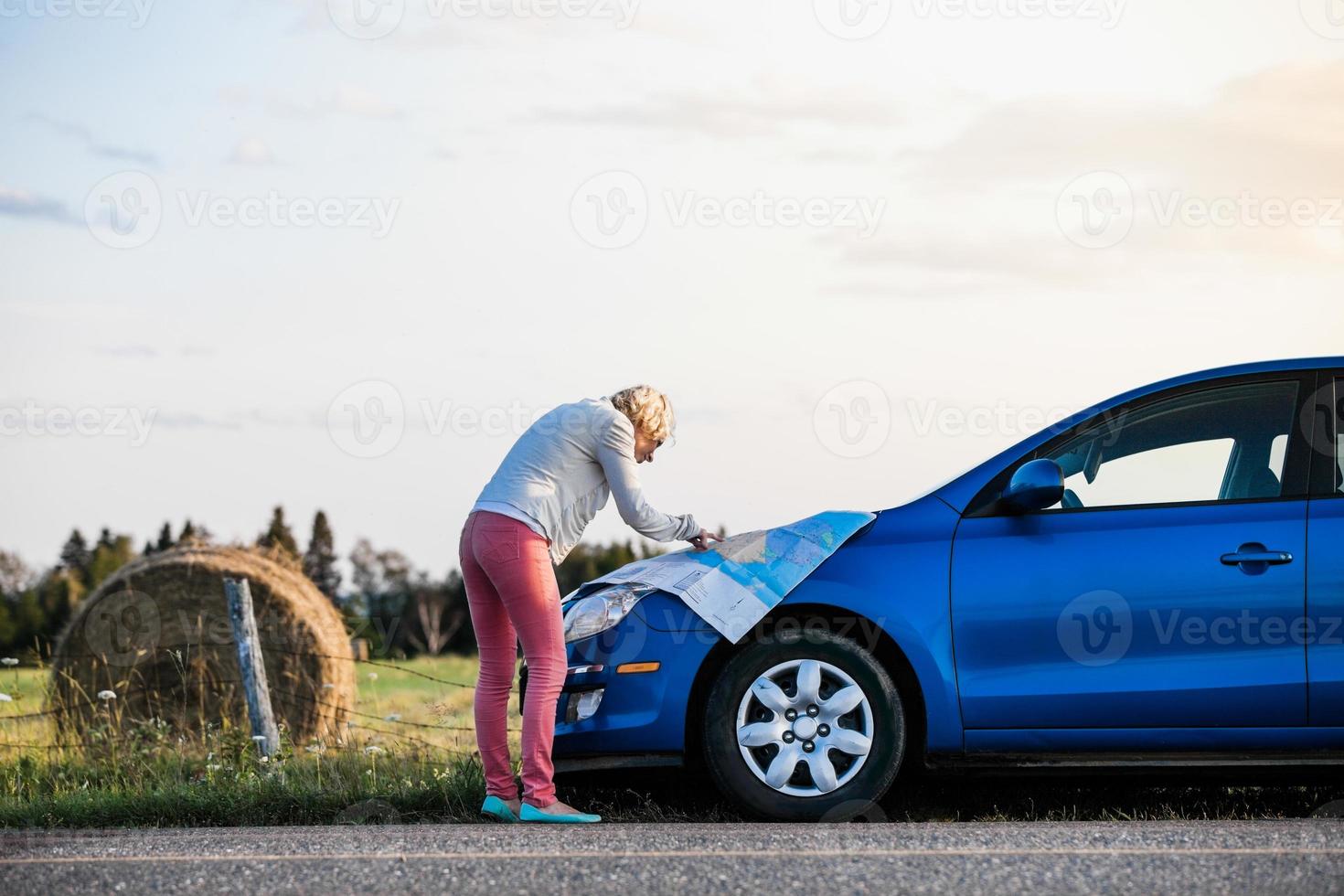 nachdenkliche Frau in einer ländlichen Szene mit Blick auf eine Karte foto