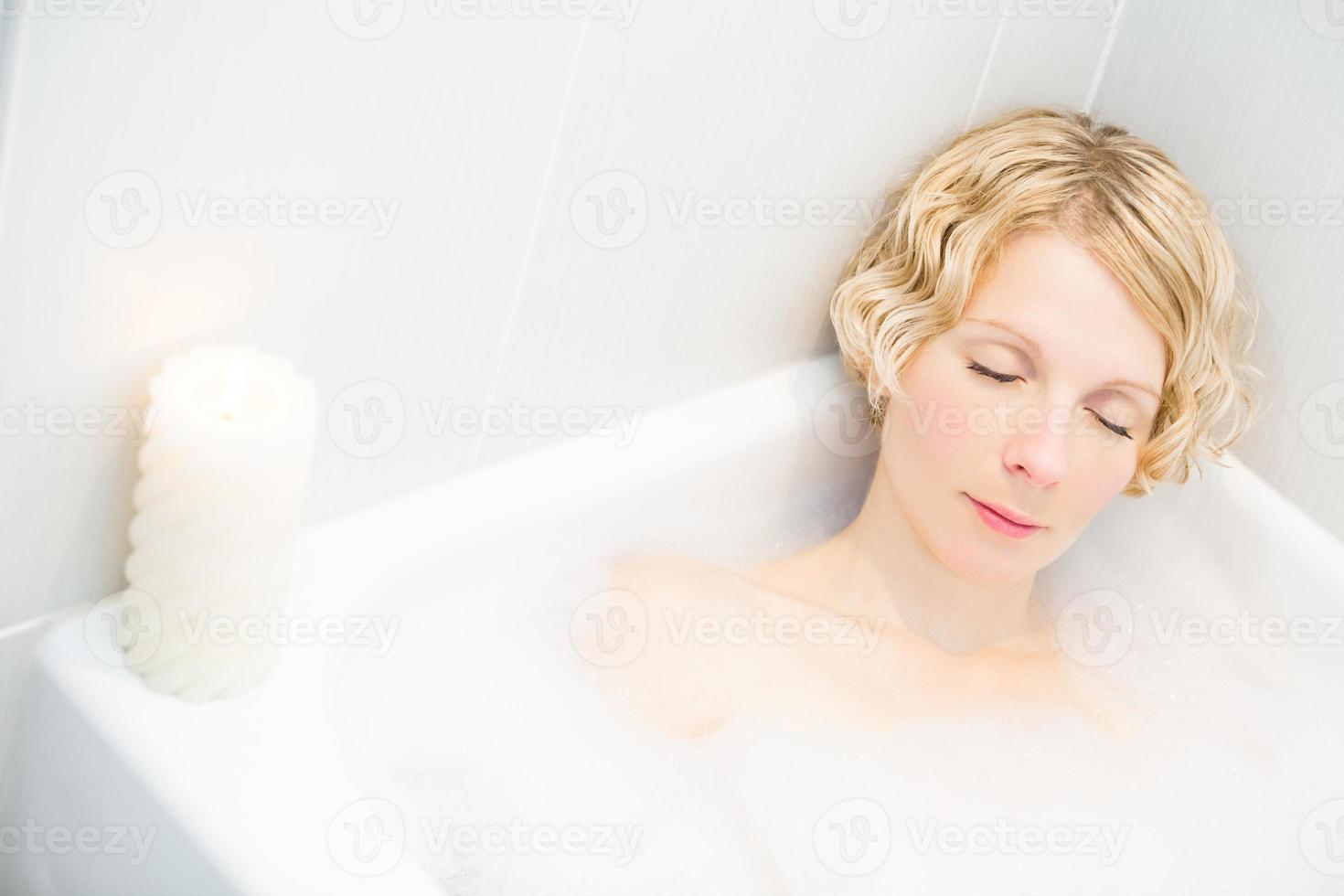 junge Frau, die sich in der Badewanne entspannt foto