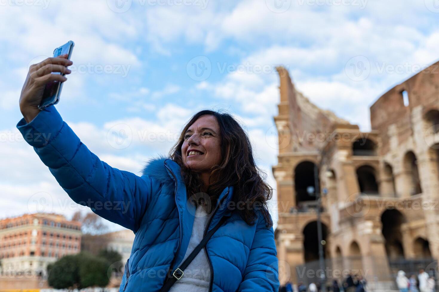 glücklich Mitte alt Frau auf Ferien nehmen ein Selfie im Vorderseite von Kolosseum Amphitheater im Rom foto