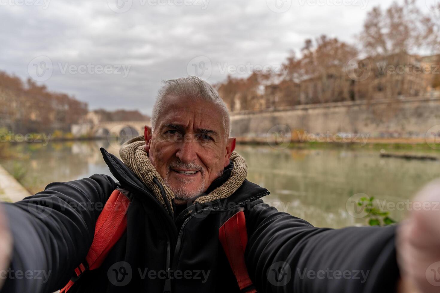 glücklich Mitte alt Mann auf Ferien nehmen ein Selfie auf das Banken von das Tiber Fluss im Rom foto