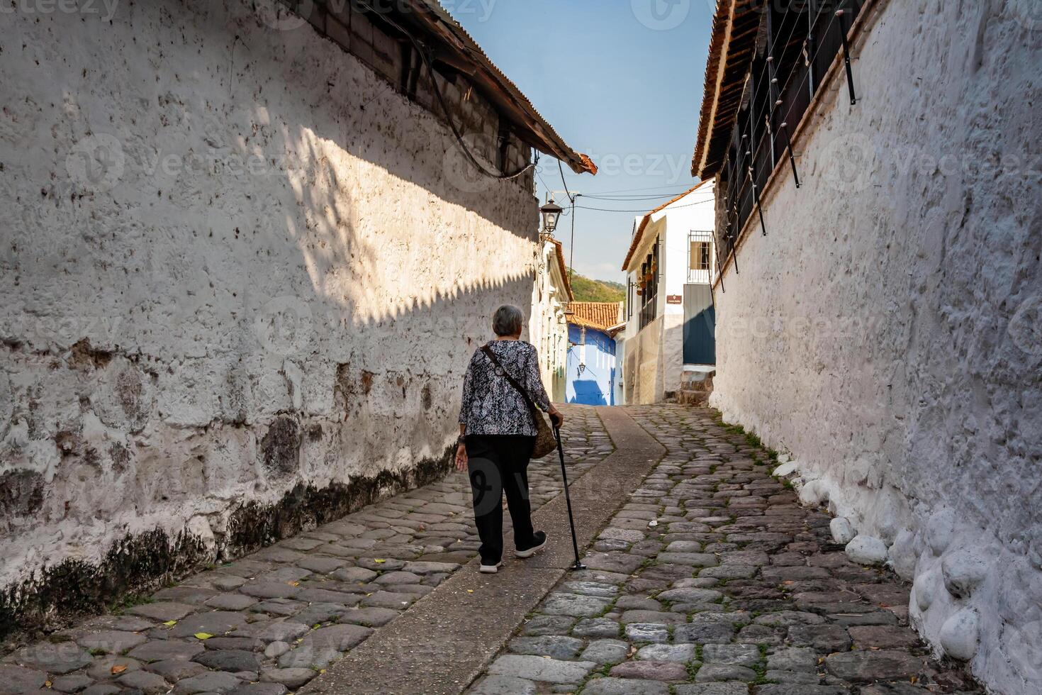 Senior Frau beim das historisch Straße von Fallen gelegen im das Center von das Erbe Stadt, Dorf von honda im das Abteilung von tolima im Kolumbien foto