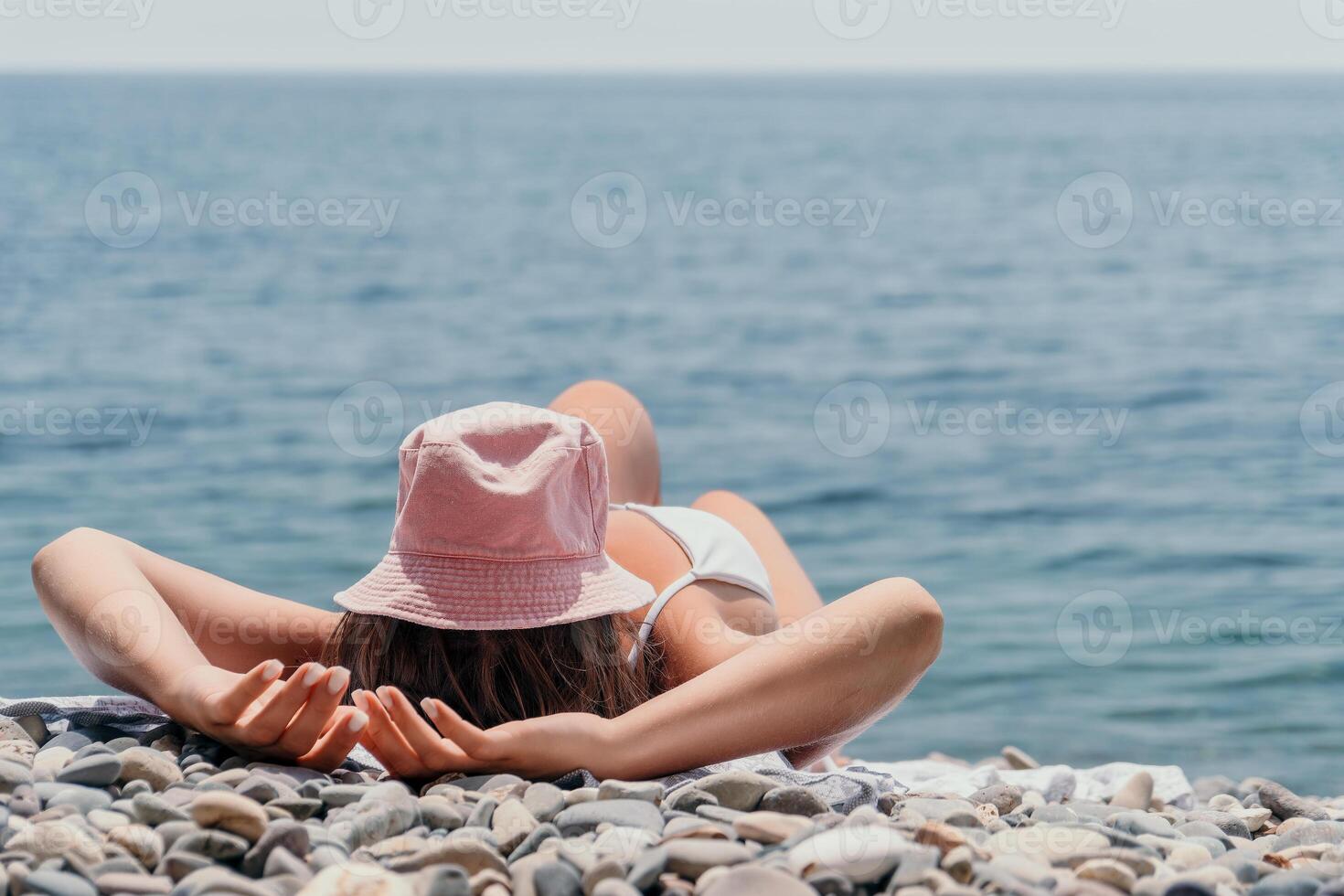 unkenntlich positiv Frau im Weiß Bikini Sonnenbaden oder Bräunen auf Strand Strand während Sommer. glücklich Tourist genießen Sonne bräunen Lügen auf Strand Stuhl Salon beim Luxus Resort foto