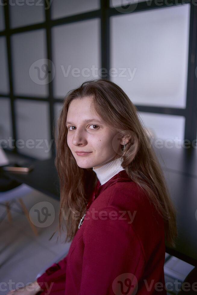 Porträt von ein jung Frau im ein rot Büro passen foto