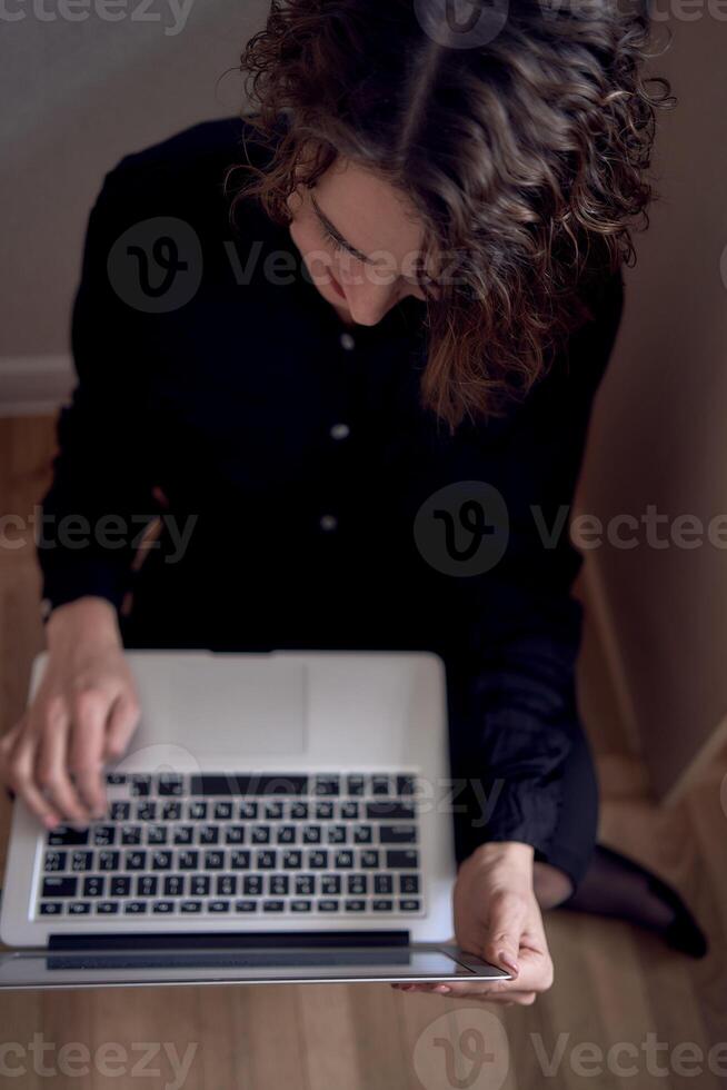 Frau Arbeit mit Laptop auf das Fußboden foto