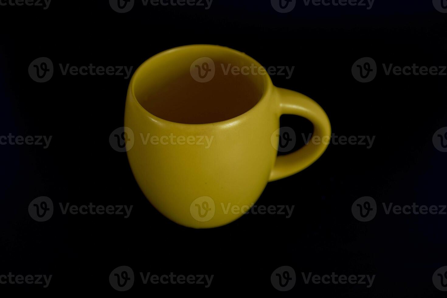 groß Gelb Tasse auf ein schwarz Hintergrund foto