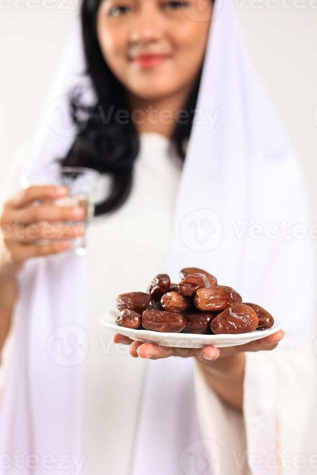 modern Muslim Frau halten Termine Obst und frisch Wasser zum iftar Ramadan foto