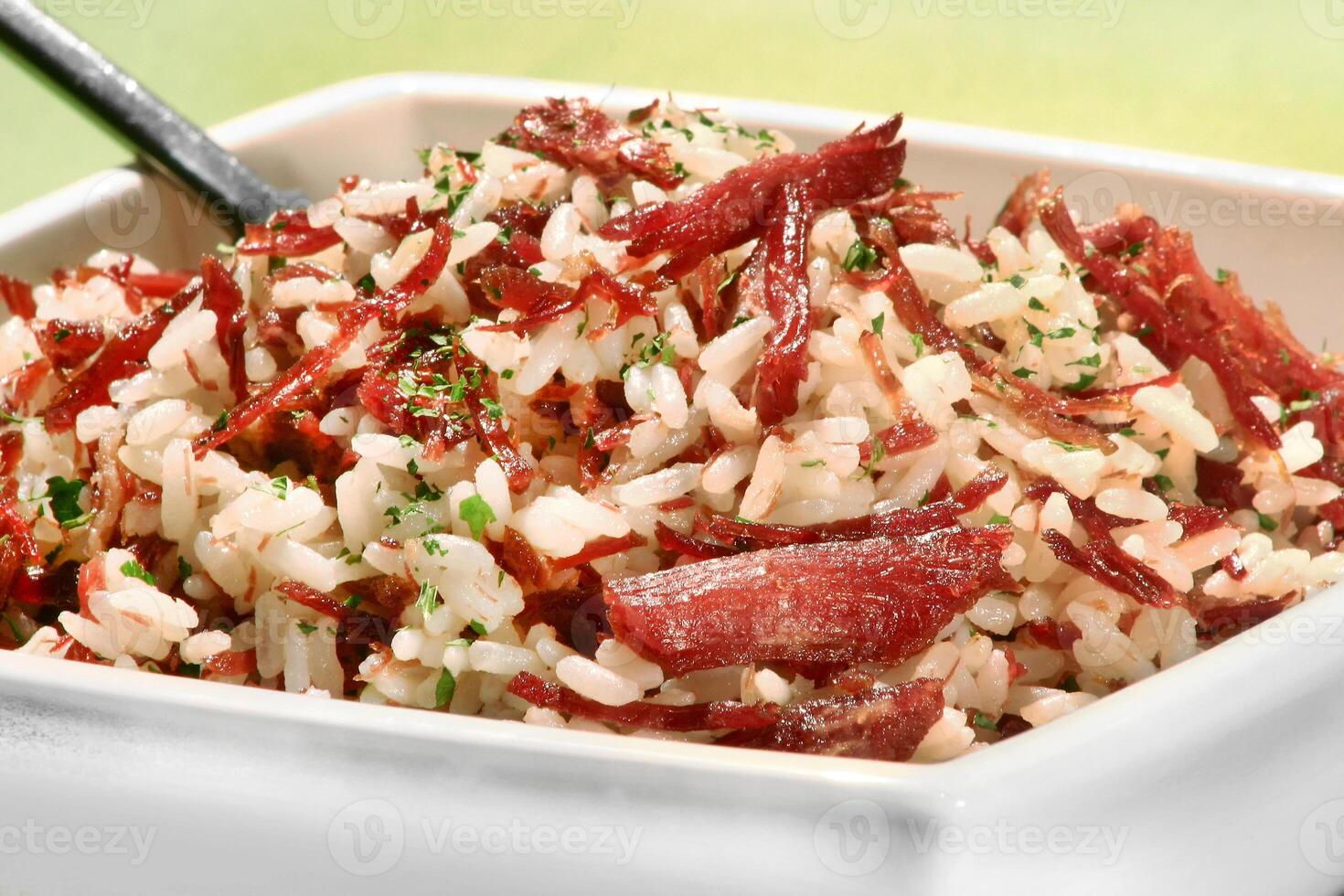 arroz de wagenheber, ein klassisch Brasilianer Gericht mit Reis, getrocknet Fleisch, geschnitten Speck, Zwiebel und Petersilie foto