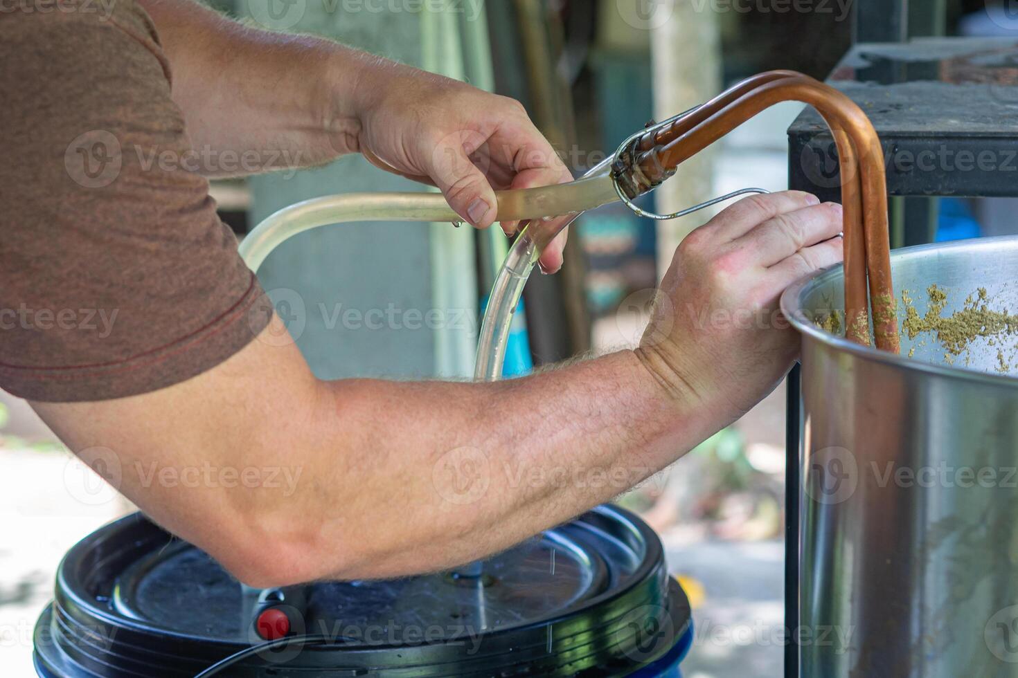 Nahansicht von Hände jung des Mannes halten ein Kupfer Eintauchen Hitze Wärmetauscher welche ist benutzt im das Kunst Bier Verfahren. selektiv Fokus. Zuhause brauen Prozess foto