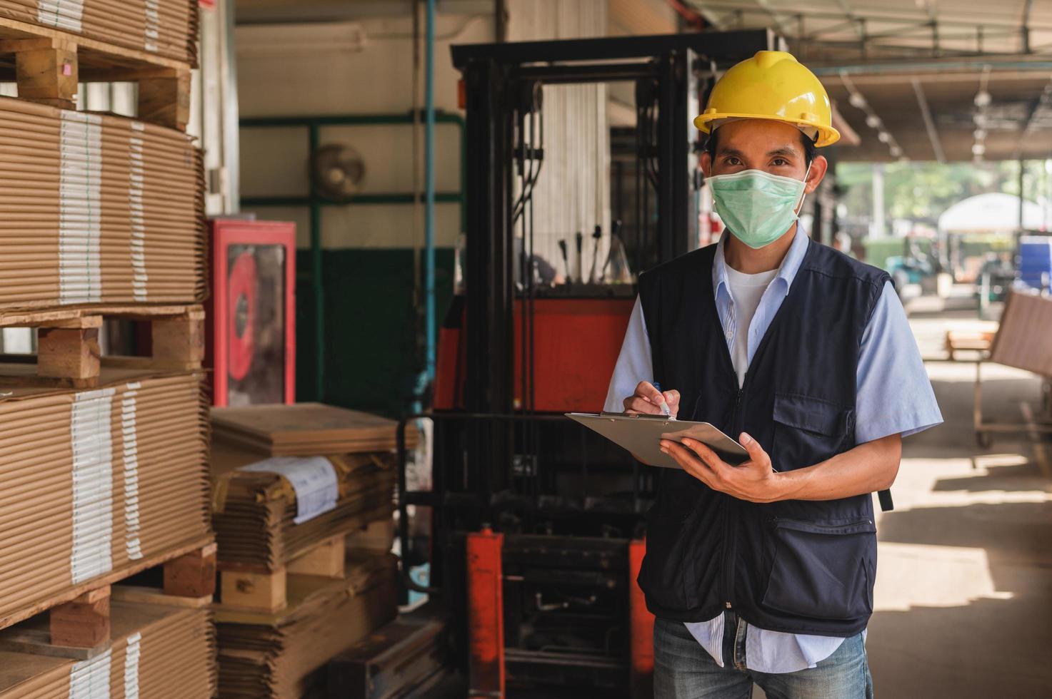 Arbeiter, der den Rohstoffbestand in der Fabrik überprüft foto