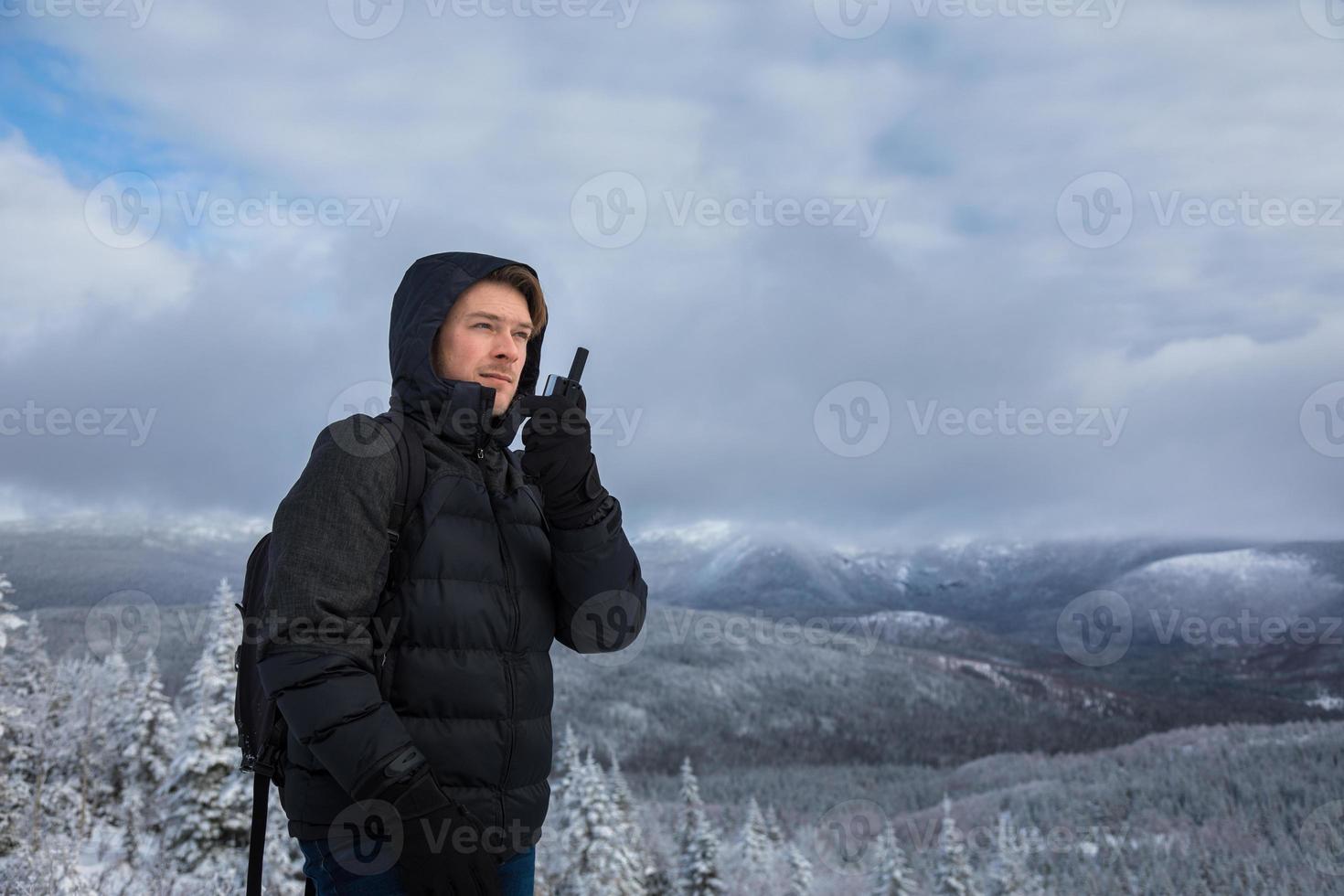 Mann auf dem Gipfel des Berges im Winter foto