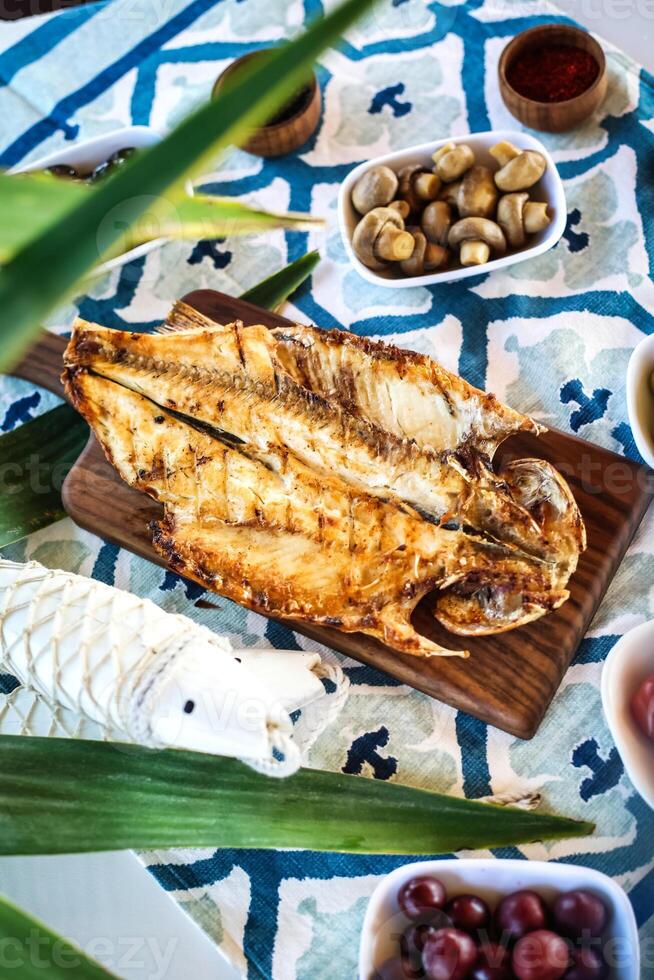 frisch gefangen Fisch auf Schneiden Tafel mit sortiert Lebensmittel foto