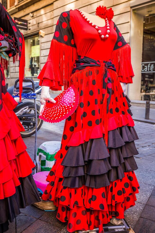 schön traditionell rot Flamenco Kleid gehängt zum Anzeige im ein Geschäft Spanien foto