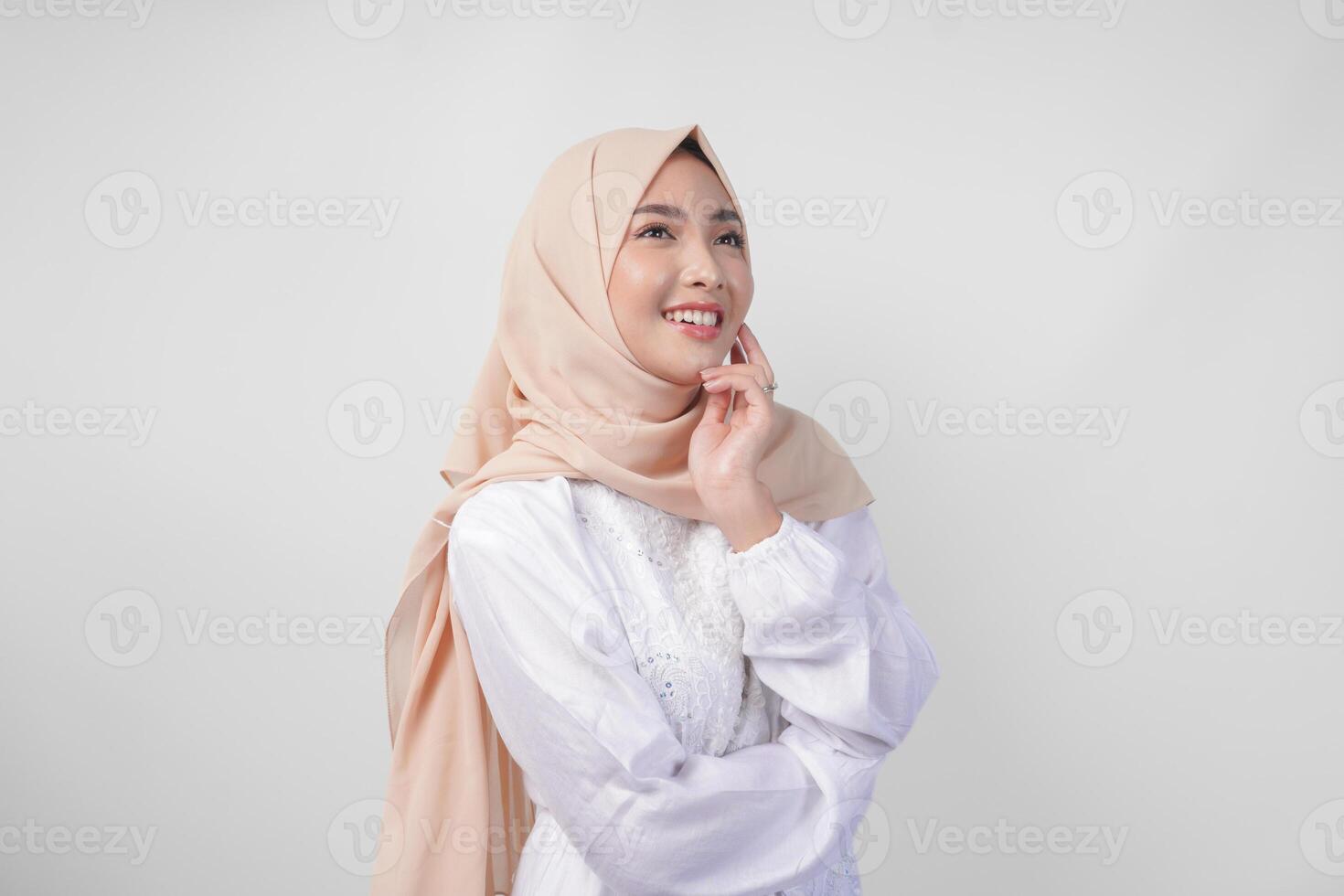 Porträt von schön asiatisch Muslim Frau mit natürlich bilden tragen Weiß Kleid und Hijab posieren auf Weiß Hintergrund im Studio. Gesichts- Haut Pflege, weiblich Schönheit Konzept foto