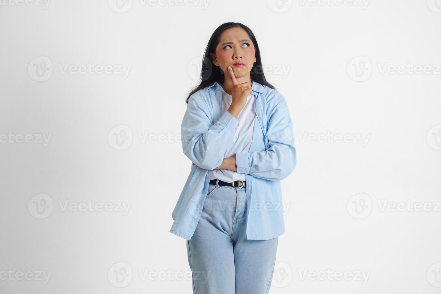 ein nachdenklich asiatisch Frau tragen Blau Hemd ist sich vorstellen ihr Gedanken, isoliert durch Weiß Hintergrund. foto