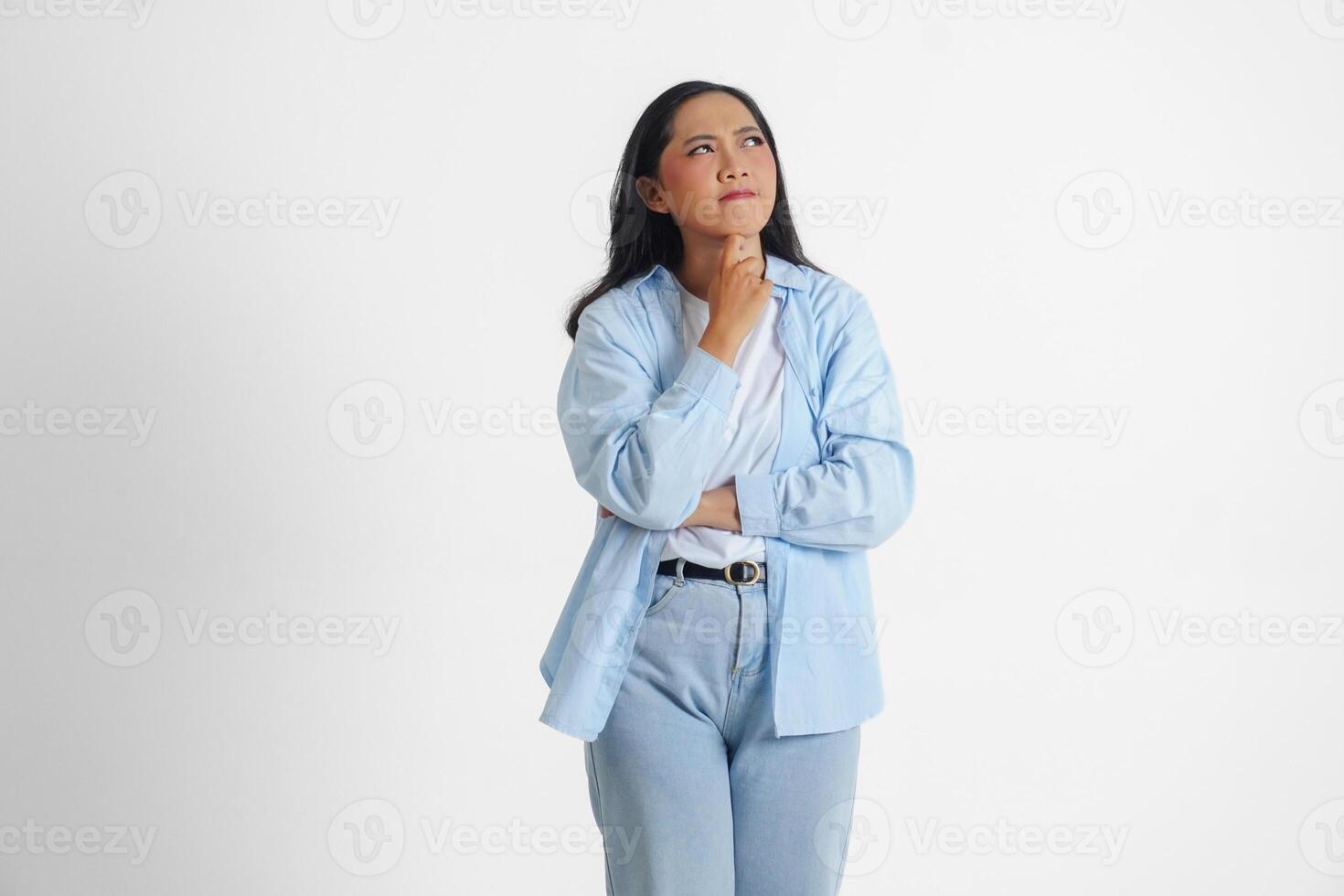 ein nachdenklich asiatisch Frau tragen Blau Hemd ist sich vorstellen ihr Gedanken, isoliert durch Weiß Hintergrund. foto