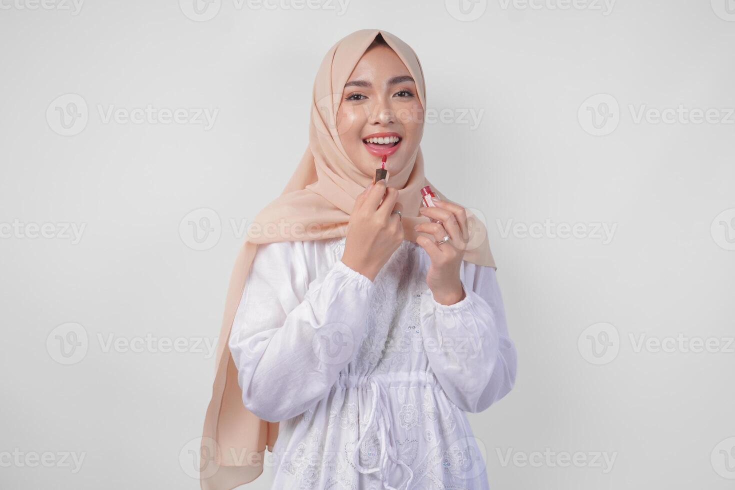 schön jung asiatisch Muslim Frau tragen Weiß Kleid und Hijab Putten auf bilden bewirbt sich Lippenstift. Mode und Kosmetika Schönheit Konzept foto