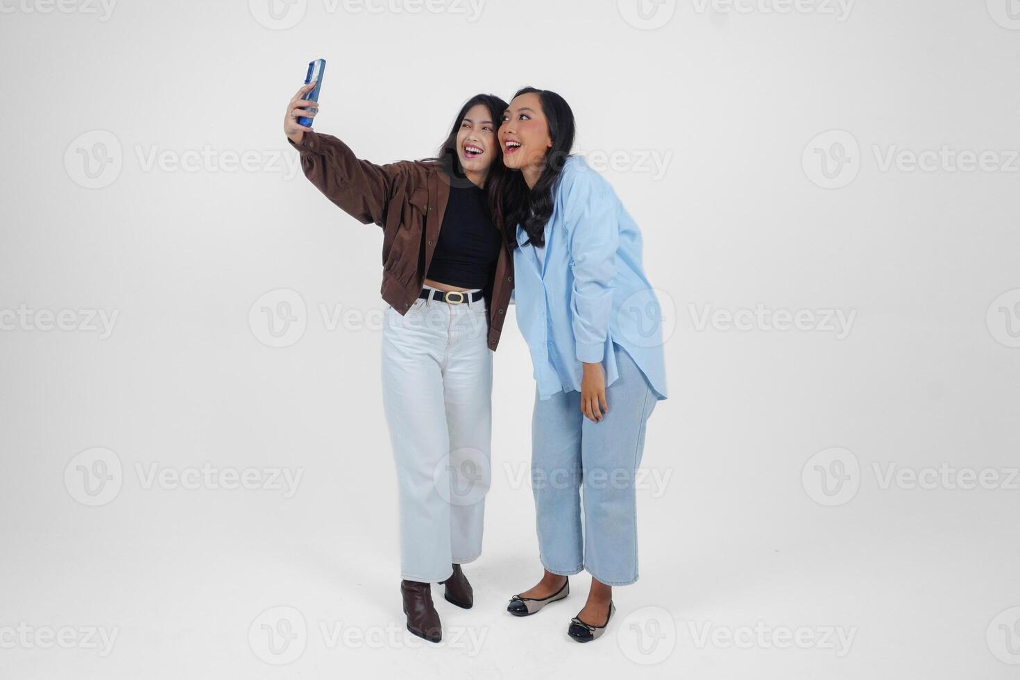 weiblich freunde Lachen und nehmen ein Spaß Selfie isoliert durch Weiß Hintergrund foto