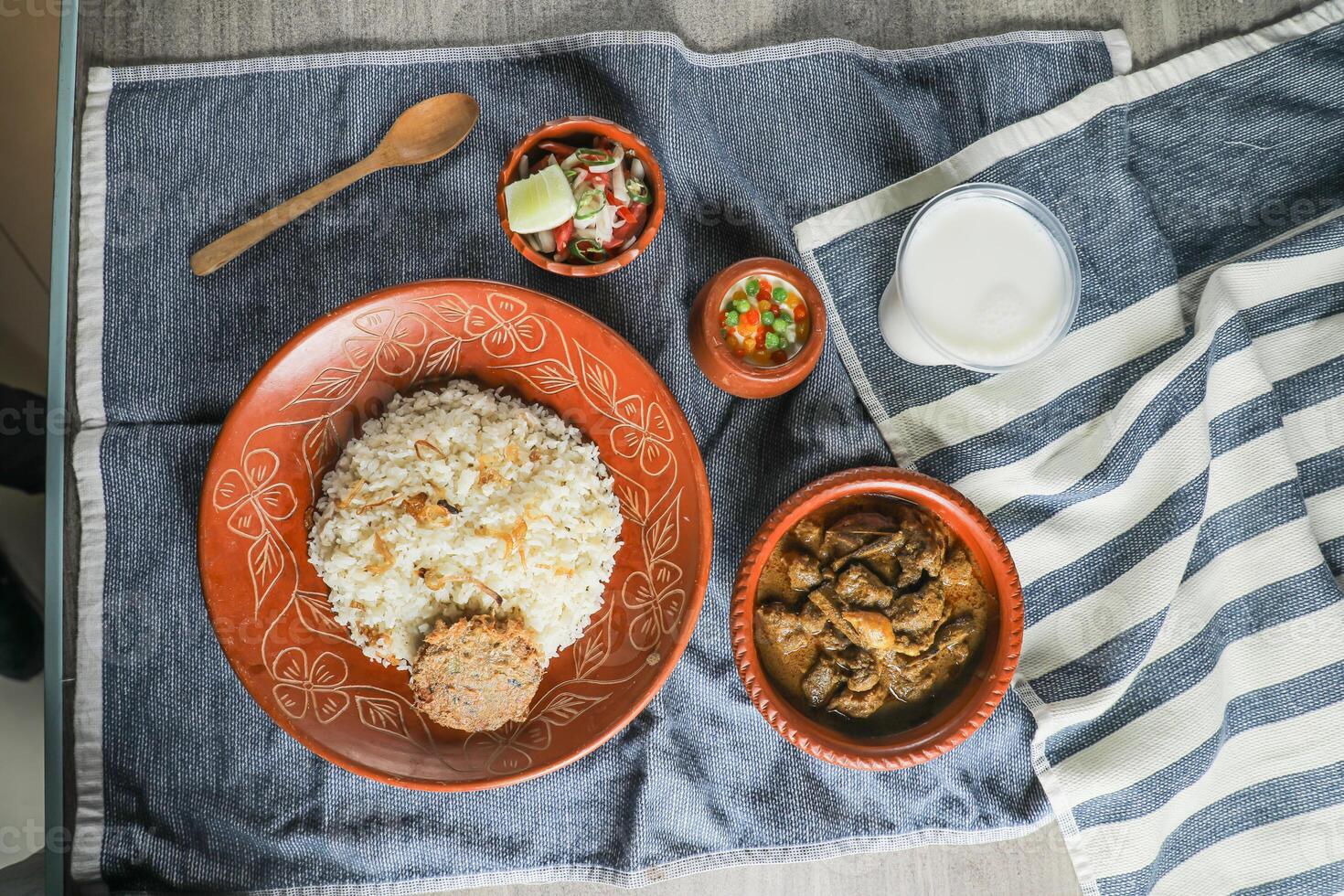 Rindfleisch Chui jhal Combo mit pulao Reis, Schami Kebab, korma Karahi, Kala Buna, boondi rabri, borhani und Salat serviert im Gericht isoliert auf Matte oben Aussicht von indisch und Bangladesch Essen foto
