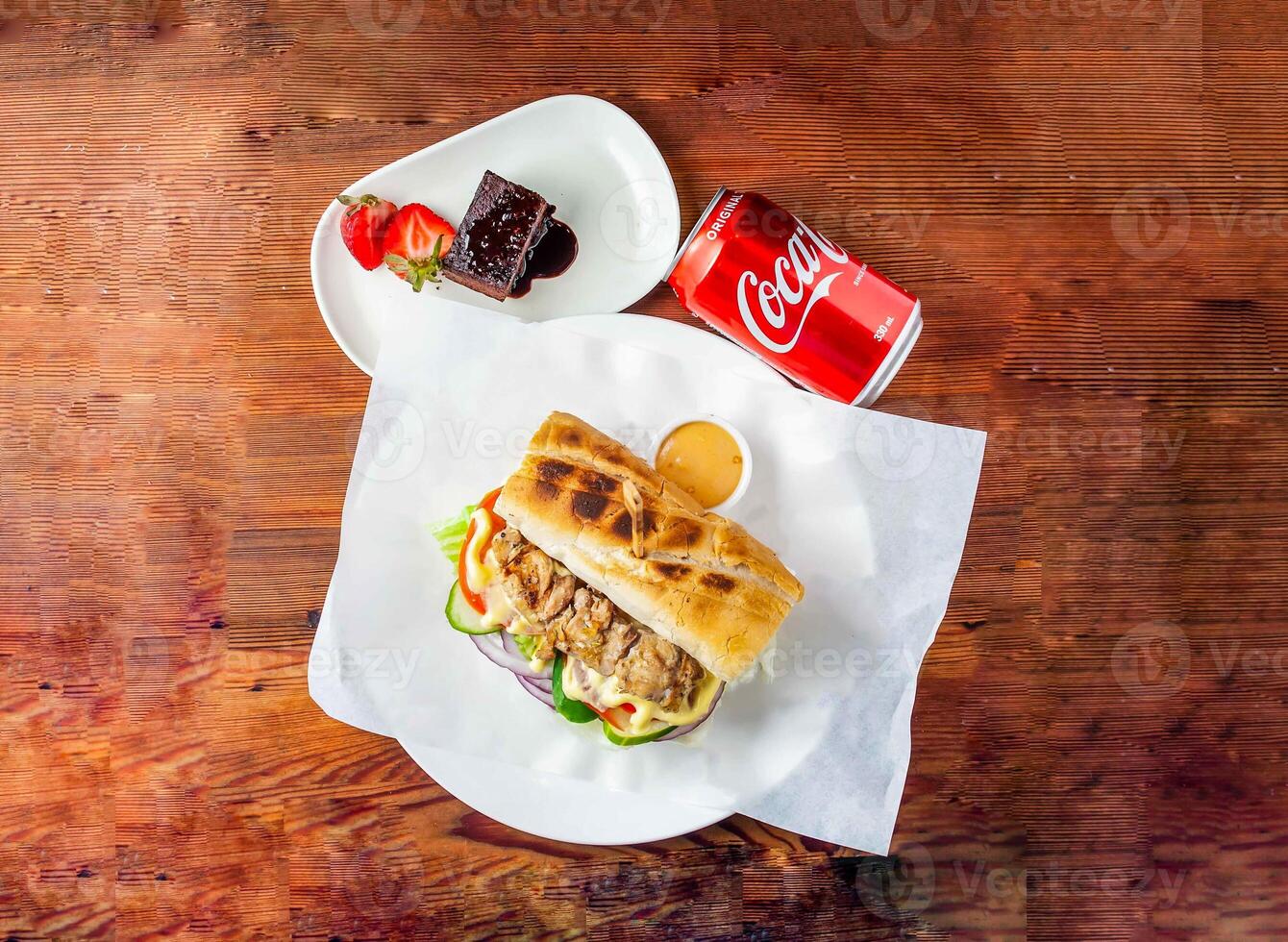 Stangenbrot Sandwich Burger gewollt mit Huhn, Gurke, Tomate, Zwiebel und Mayonnaise tauchen, Brownie und Koks können 330 ml serviert im Gericht isoliert auf hölzern Tabelle oben Aussicht von Hong kong Essen foto