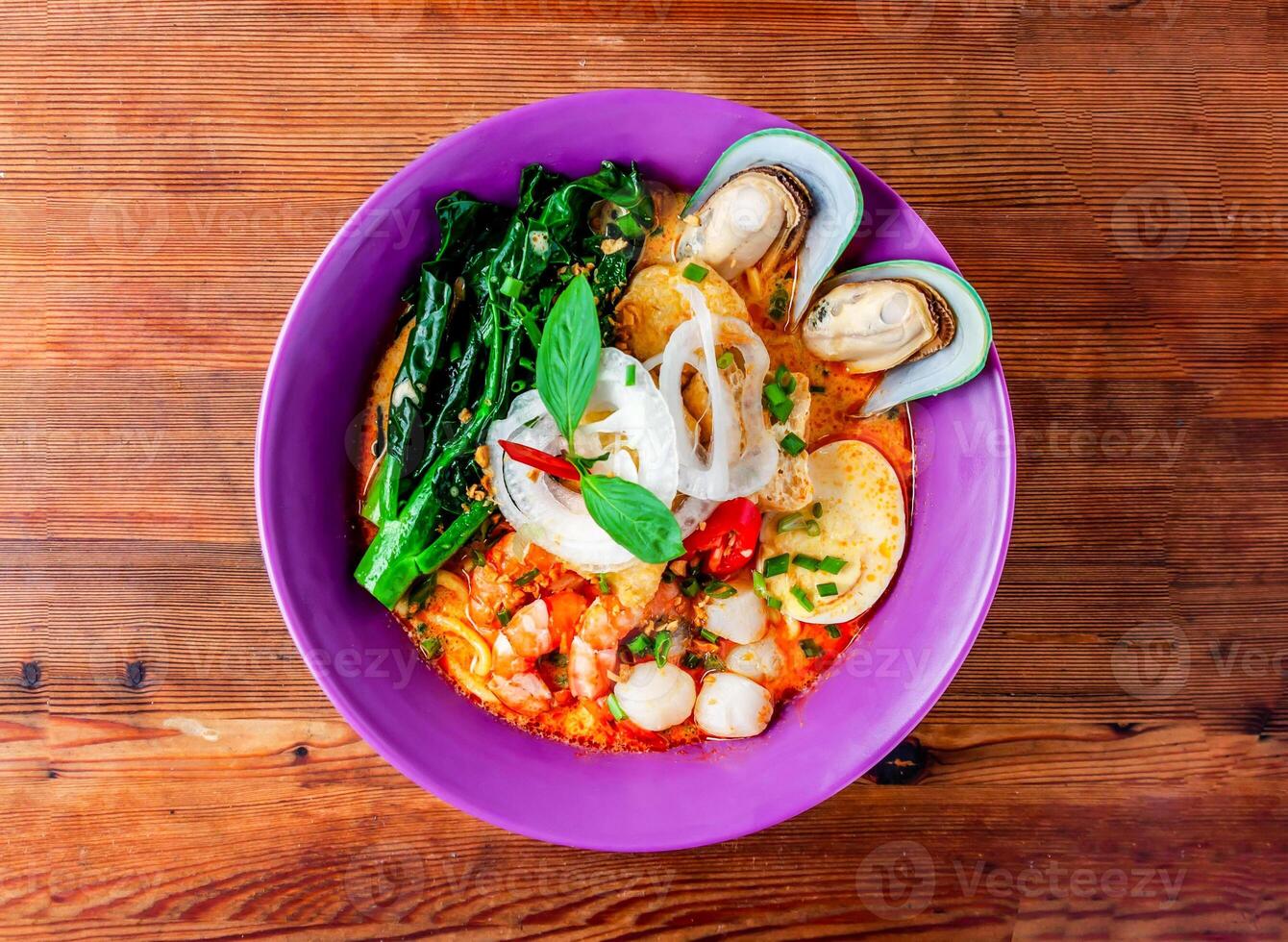 Meeresfrüchte Laksa Suppe mit Garnele, Garnele, Meer Hülse, Nudeln und gekocht Ei serviert im Gericht isoliert auf hölzern Tabelle oben Aussicht von Hong kong Essen foto