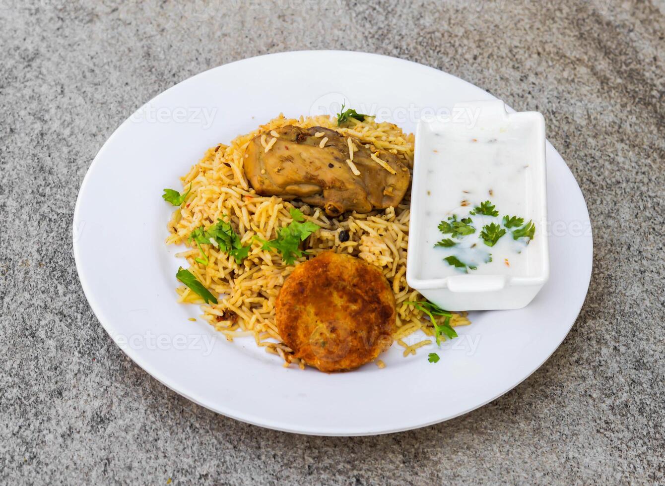 Hähnchen Biryani oder pulao mit Schami Kabab tikki und Minze Raita serviert im Gericht isoliert auf Hintergrund oben Aussicht von indisch Gewürze und pakistanisch Essen foto