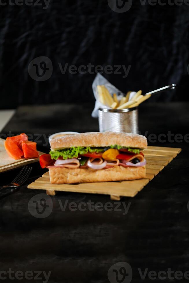 Ciabatta geräuchert Schinken Sandwich isoliert auf hölzern mit Mayonnaise tauchen und Französisch Fritten Eimer Tafel Seite Aussicht von Italienisch schnell Essen auf grau Hintergrund foto