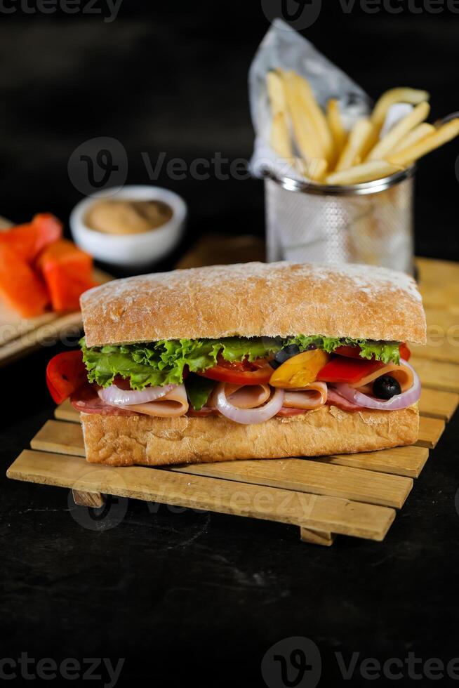 Ciabatta geräuchert Schinken Sandwich isoliert auf hölzern mit Mayonnaise tauchen und Französisch Fritten Eimer Tafel Seite Aussicht von Italienisch schnell Essen auf grau Hintergrund foto