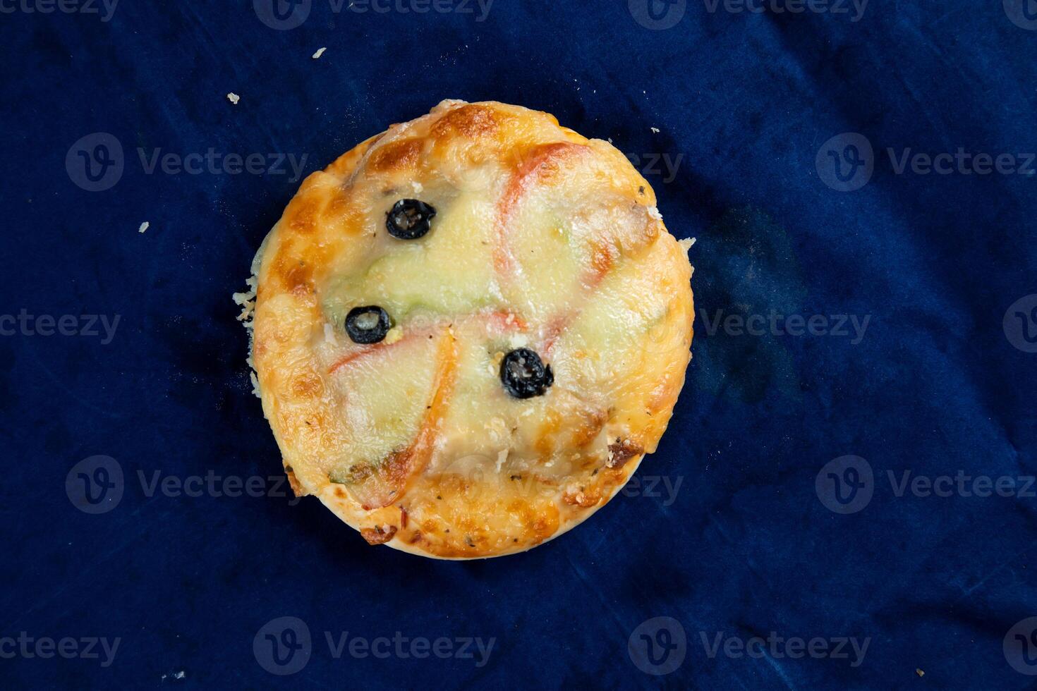Mini Pizza isoliert auf Blau Hintergrund oben Aussicht von Bohnenkraut Snack schnell Essen foto